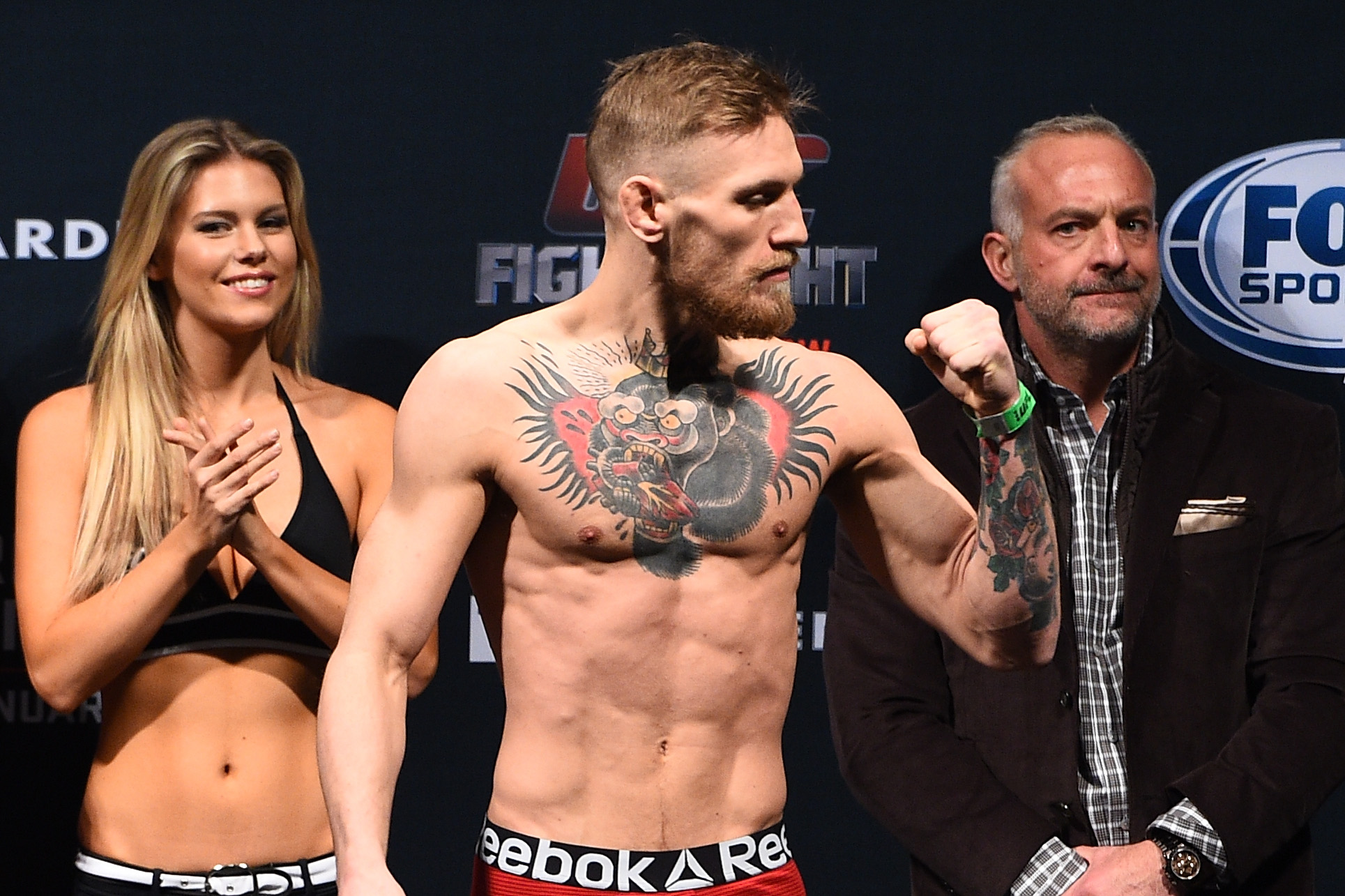 McGregor strikes another pose moments later during the same weigh-in event in Boston. Viewed from a different angle, his slender frame and pronounced muscle definition underscored the physical demands of competing at 145 pounds before later moves to heavier weight classes transformed his appearance.