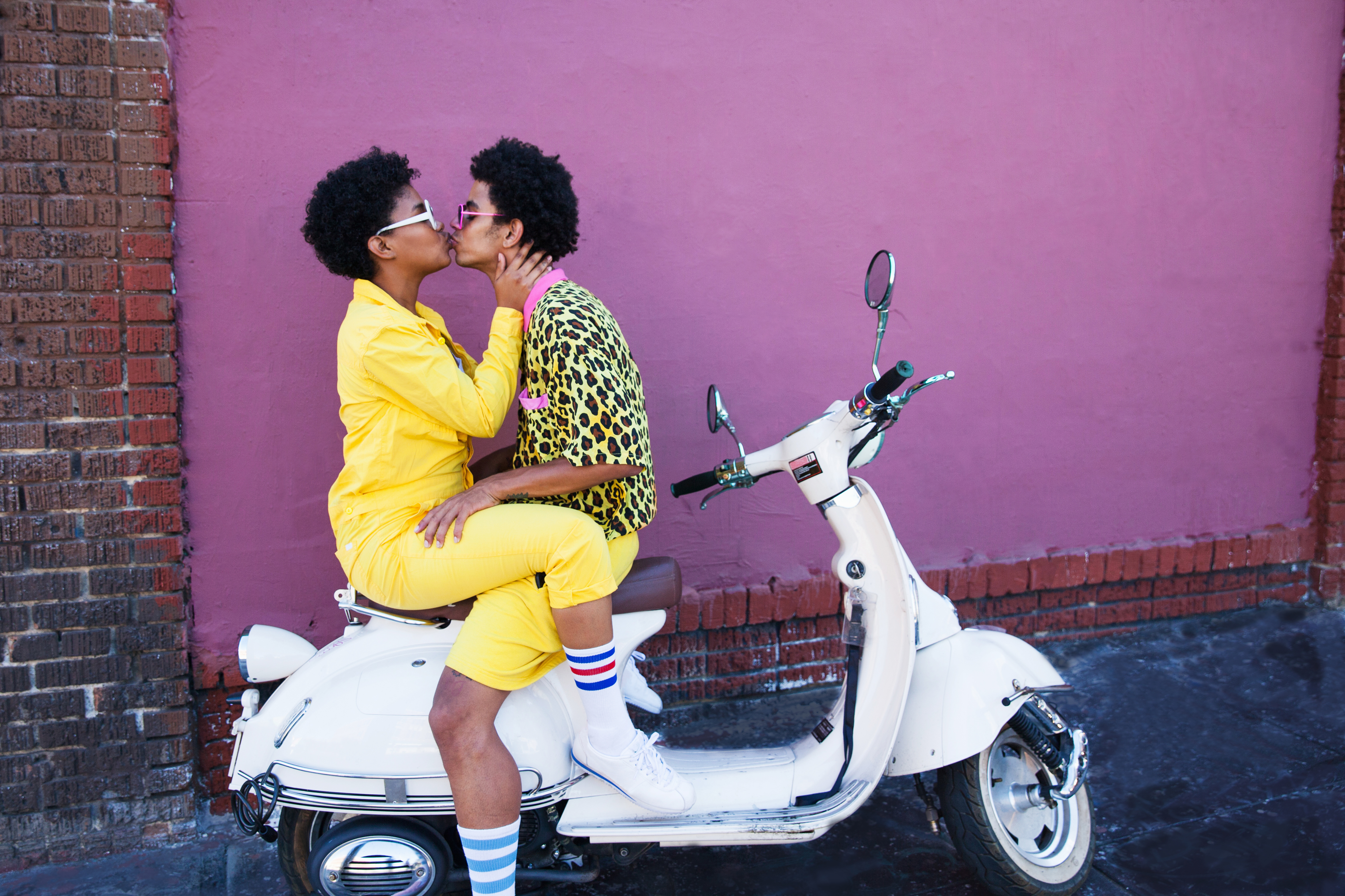 A couple kissing on the back of a scooter. | Source: Getty Images