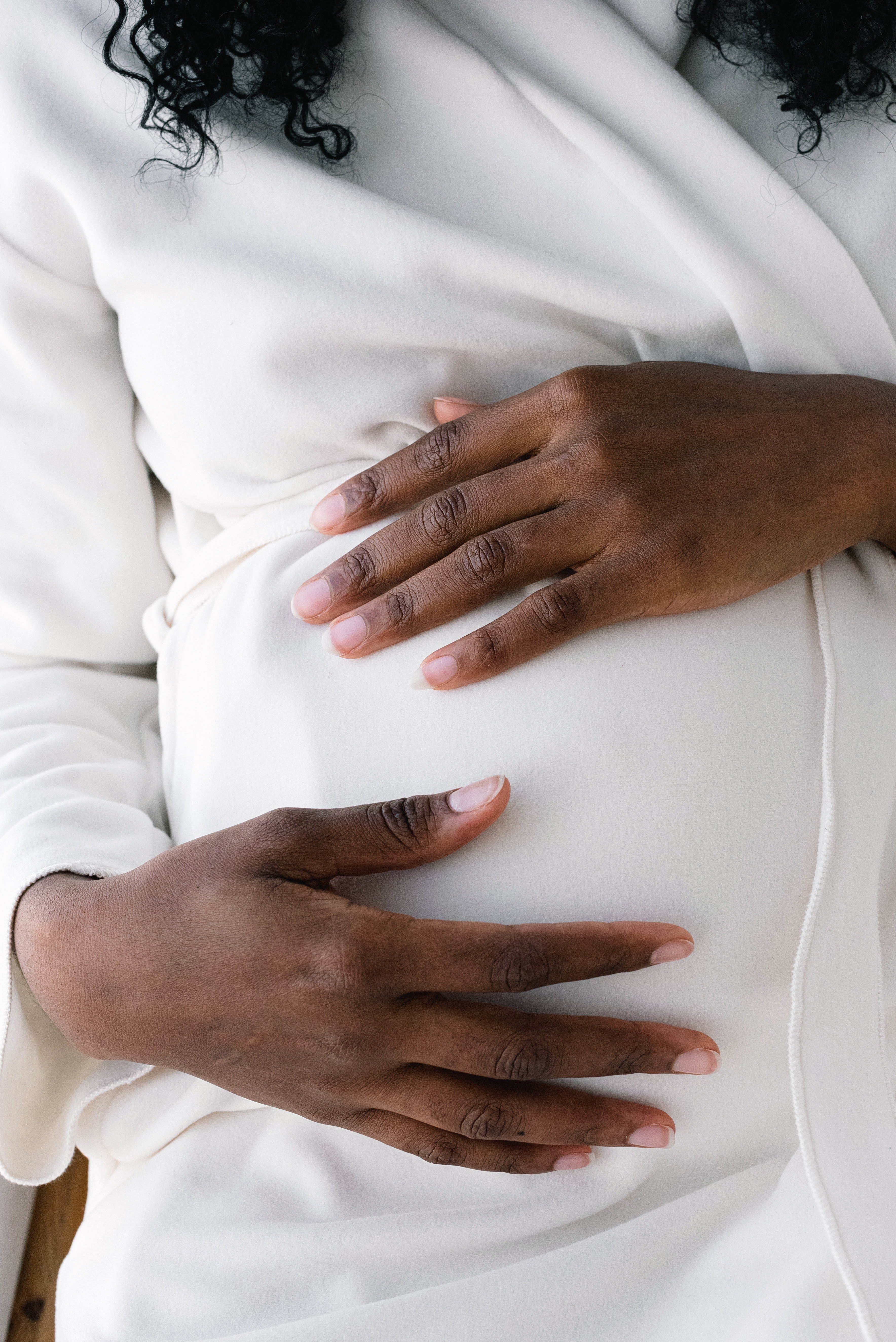  A pregnant woman touching her belly bump. | Photo: Pexels/SHVETS production