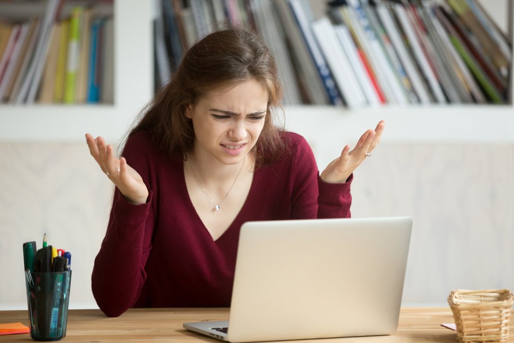 A frustrated and annoyed woman sitting in front of  laptop | Photo: Shutterstock/fizkes