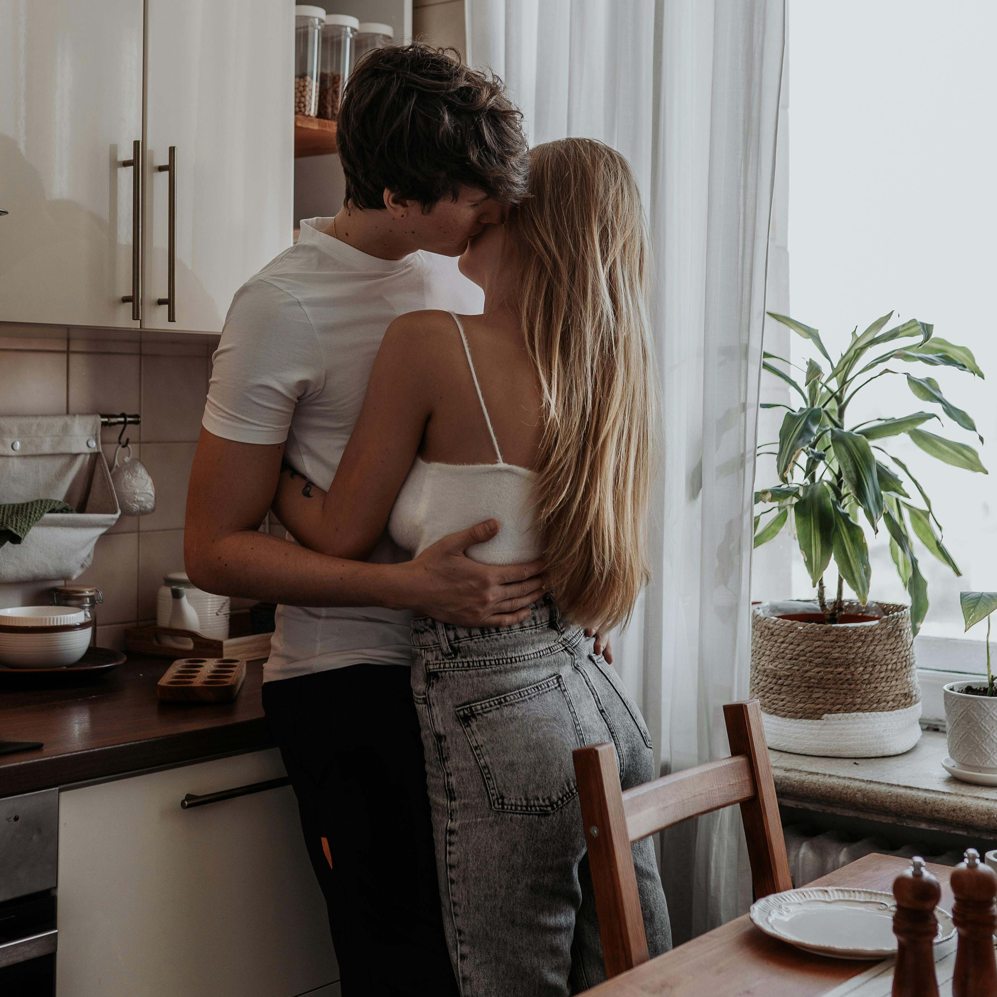 A man embracing a woman in a kitchen | Source: Pexels