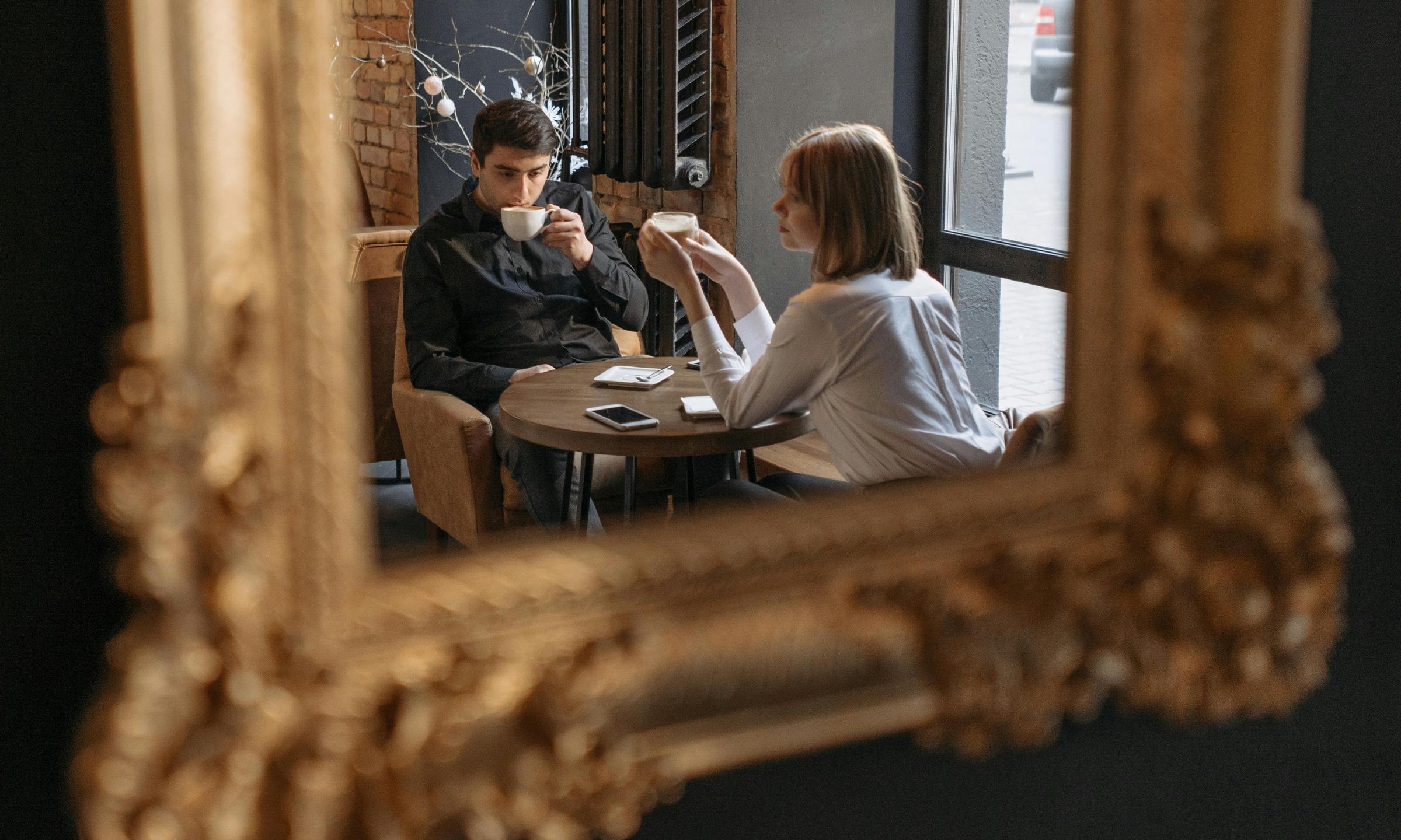 A man and woman seen reflected in a cafe mirror | Source: Pexels