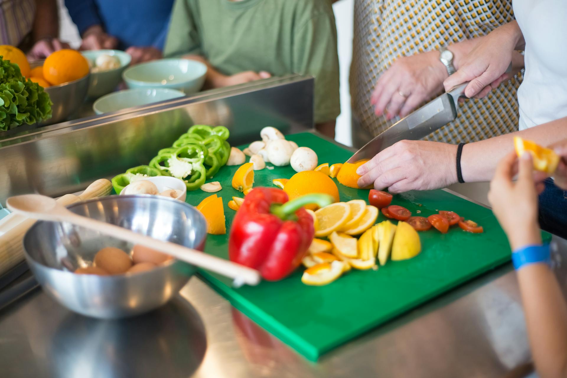 A closeup shot of family members preparing food in the kitchen | Source: Pexels