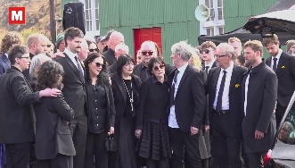 Loved ones formed a solemn group outside the service, reflecting the deep sense of loss and togetherness following Moya Brennan's passing. | Source: Instagram/irishmirror