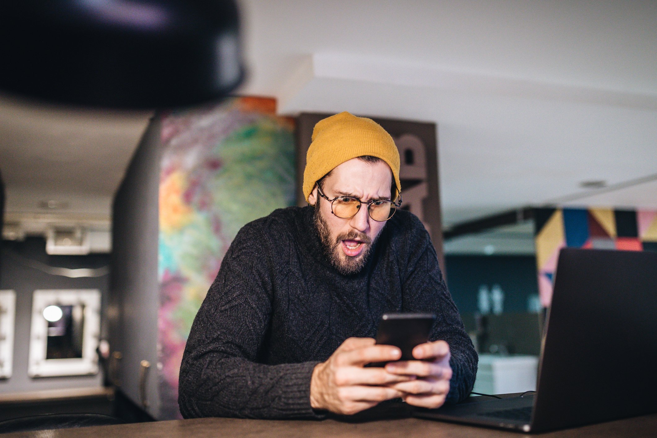 A bearded hipster looked shocked as he stares at his smartphone, Serbia | Source: Getty Images