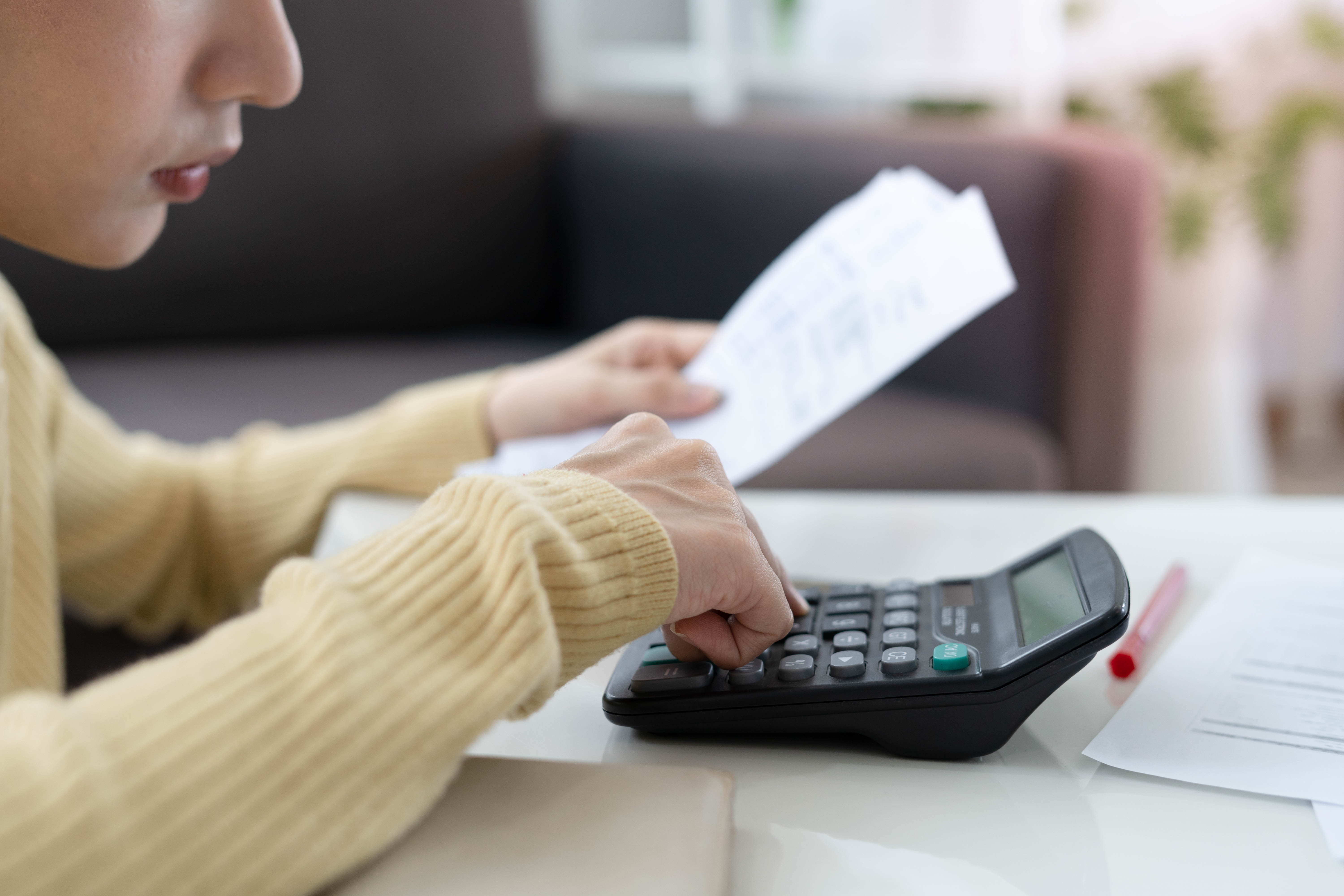 A woman calculating her expenses | Source: Shutterstock