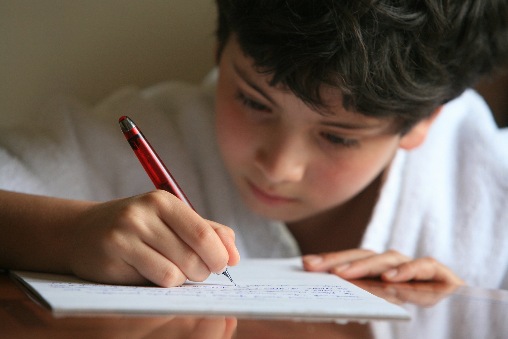 Niño concentrado escribiendo una carta. | Foto: Getty Images
