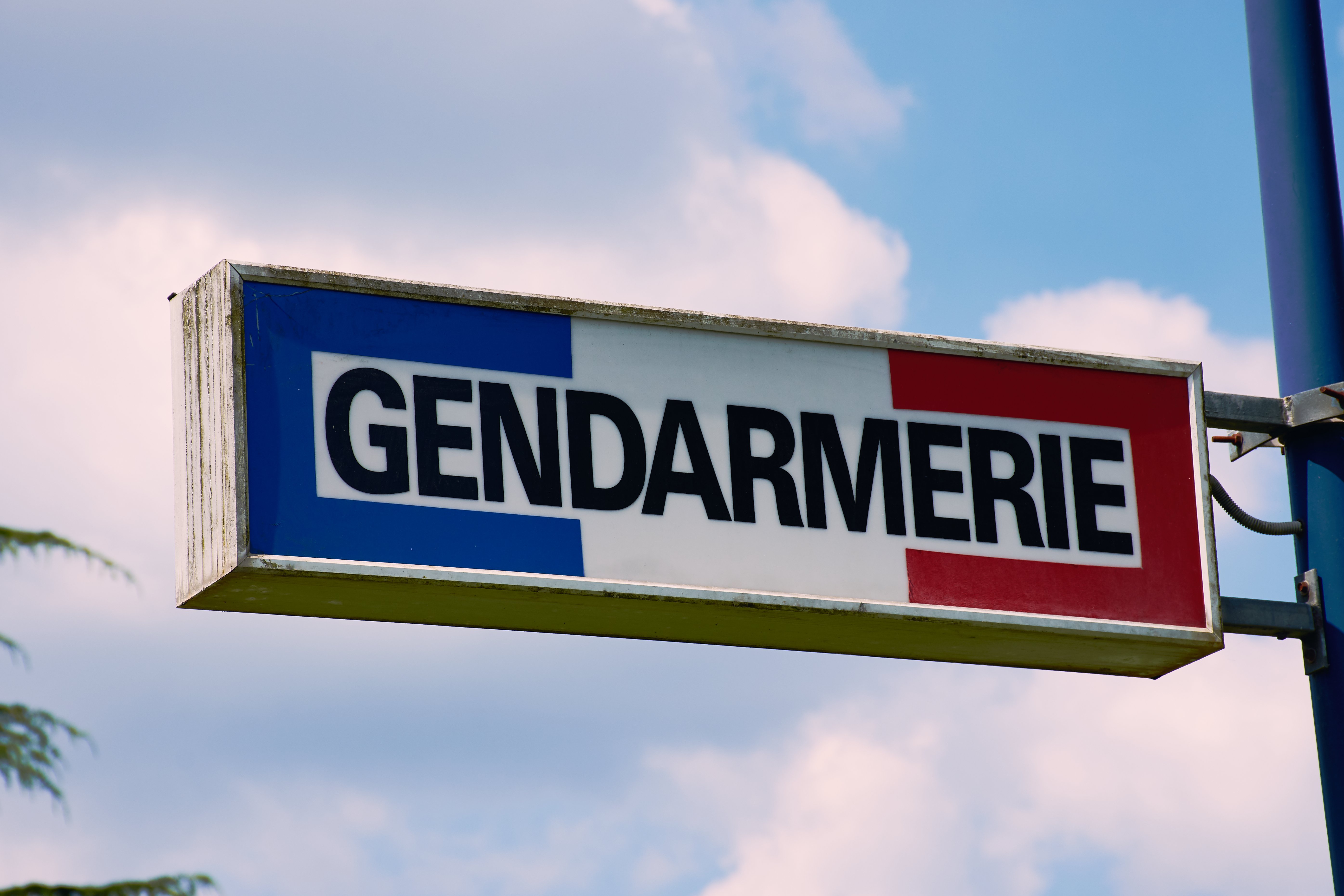 Signe de la gendarmerie française sur un poteau. | Photo : Shutterstock
