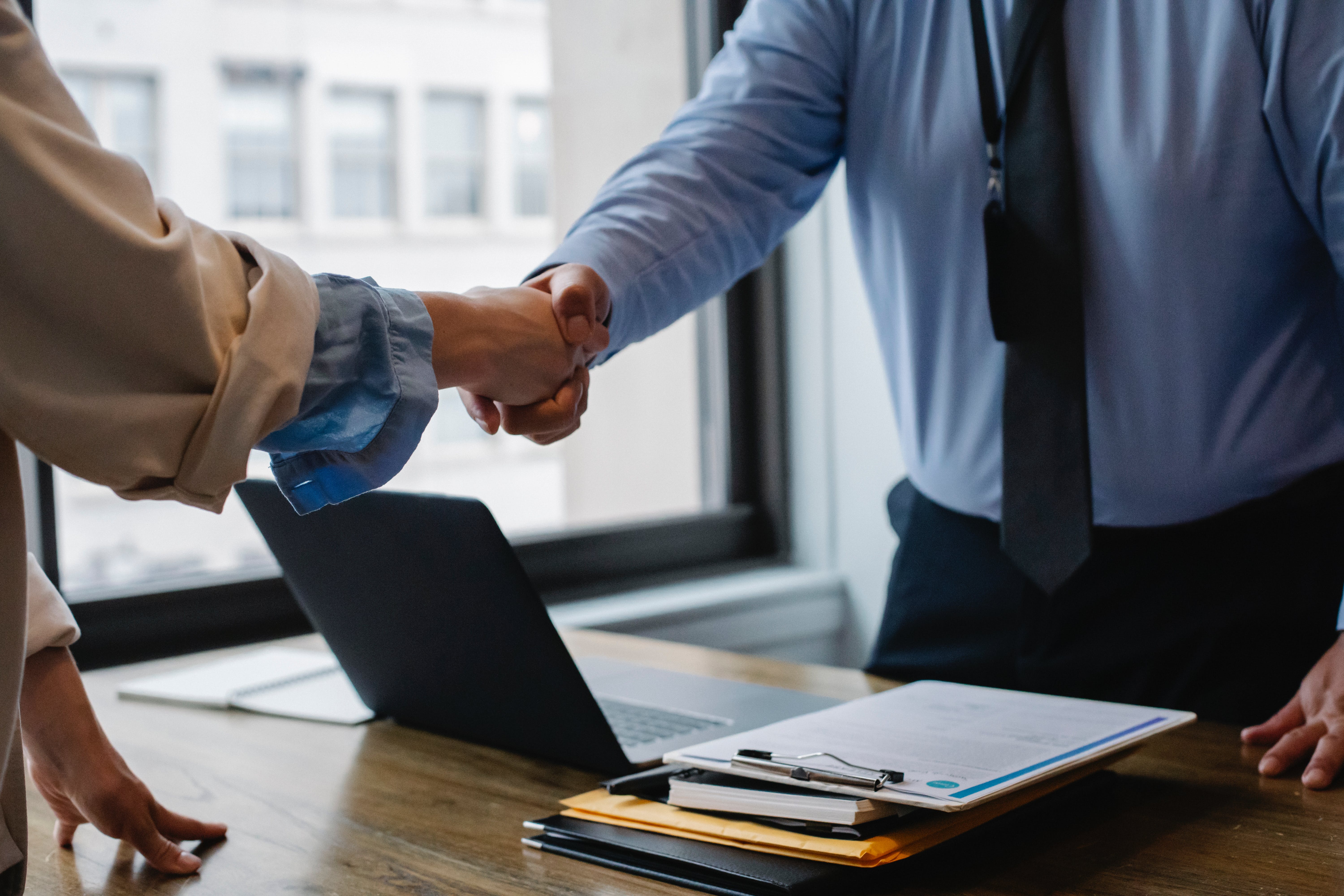 Two people shaking hands at an office | Source: Pexels