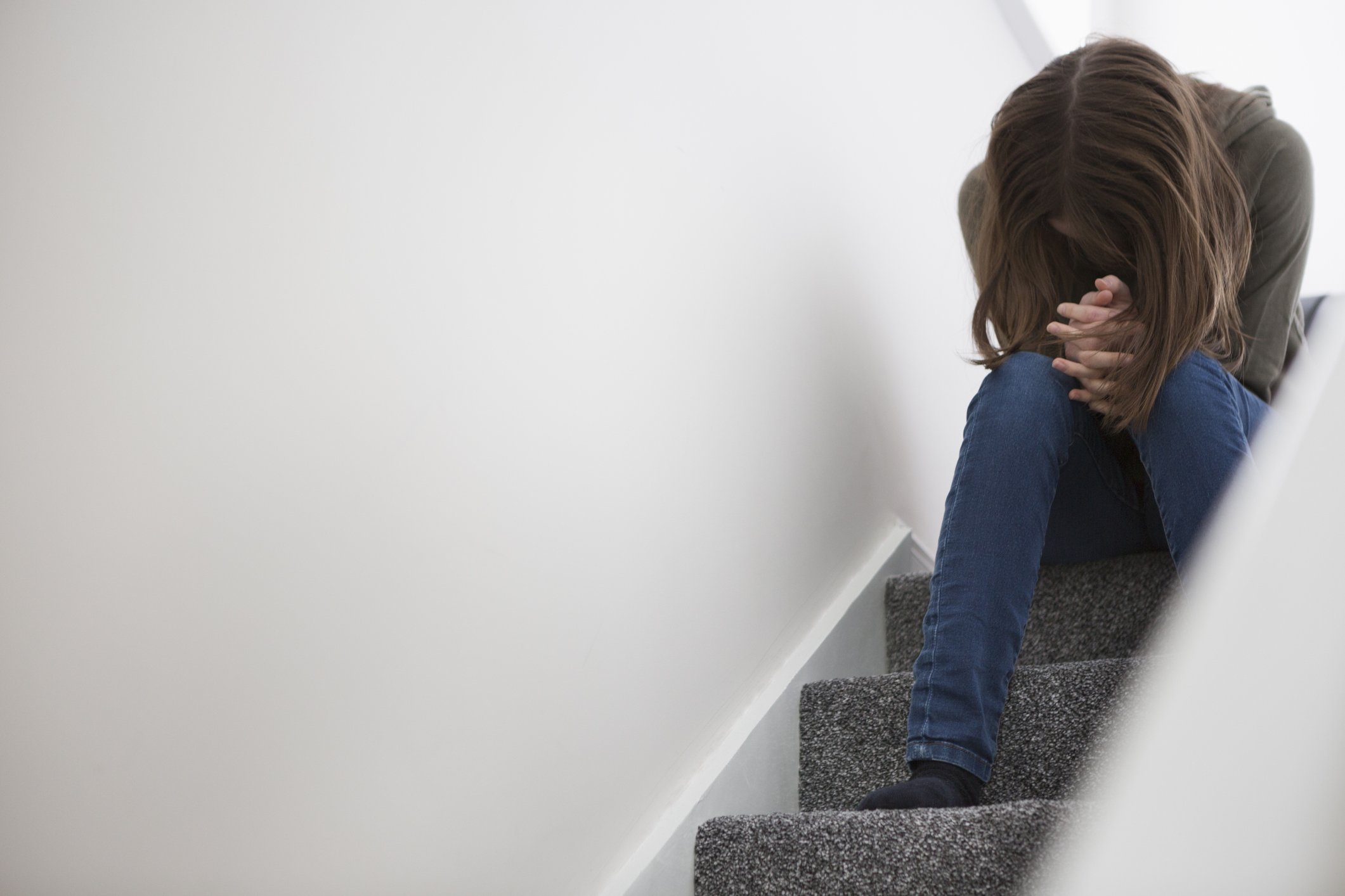 Worried teenage girl sitting on the stairs. | Photo: Getty Images