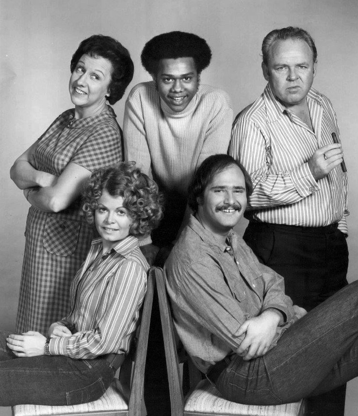 Cast of  "All In the Family" in 1973. Standing, from left: Jean Stapleton (Edith Bunker), Mike Evans (Lionel Jefferson), Carroll O'Connor (Archie Bunker). Seated: Sally Struthers (Gloria Bunker Stivic) and Rob Reiner (Mike Stivic). | Source: Wikimedia Commons.