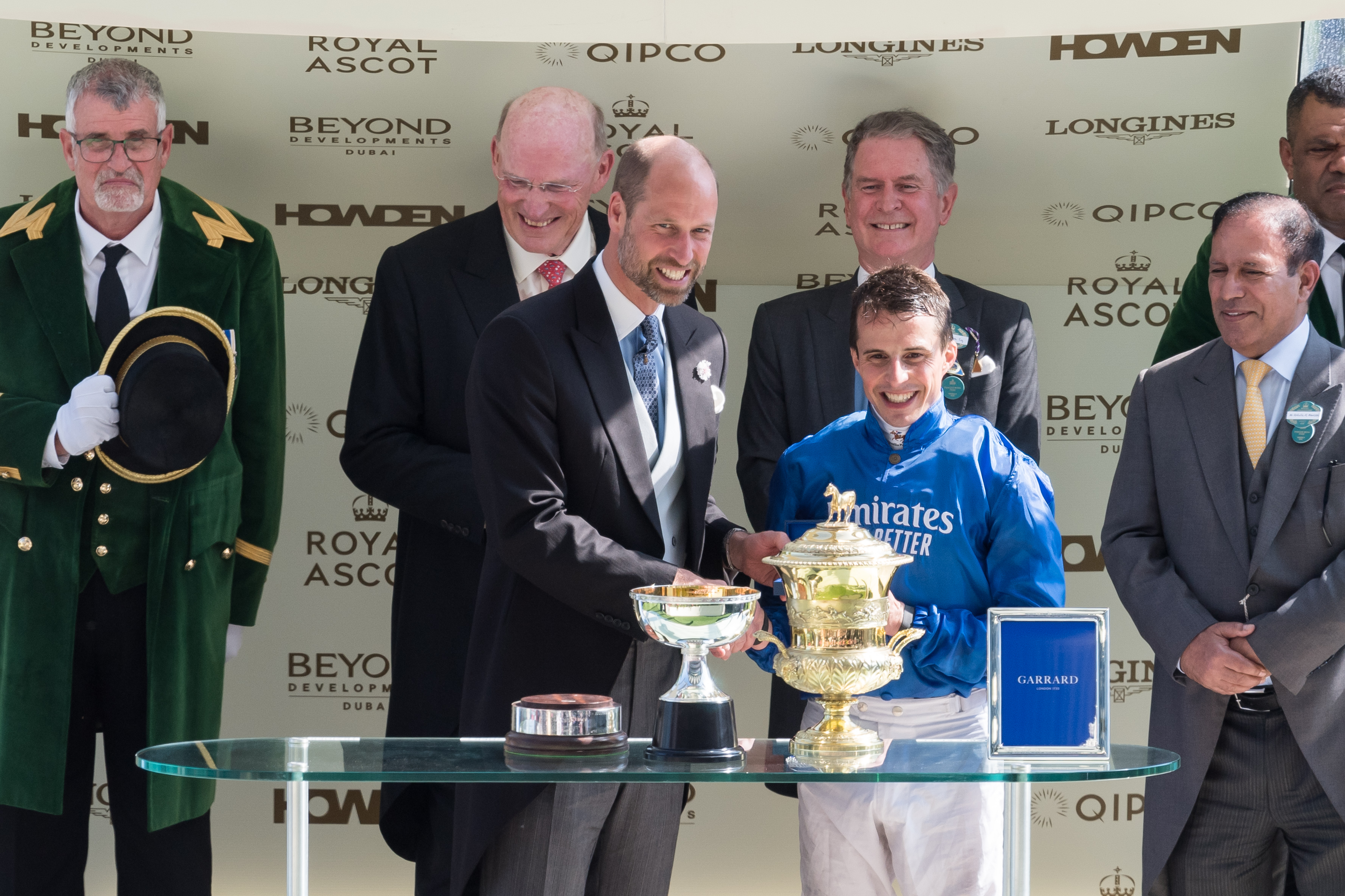 Prince William congratulates the winning jockey with a handshake and smile during the trophy presentation for the Prince of Wales' Stakes, celebrating Ombudsman's victory on day two of Royal Ascot.