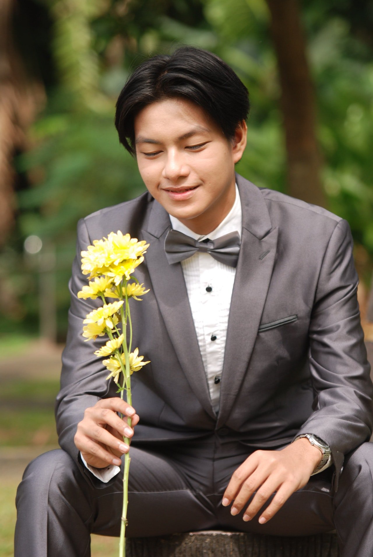 Un elegante hombre joven con una flor en su mano. | Foto: Pexels