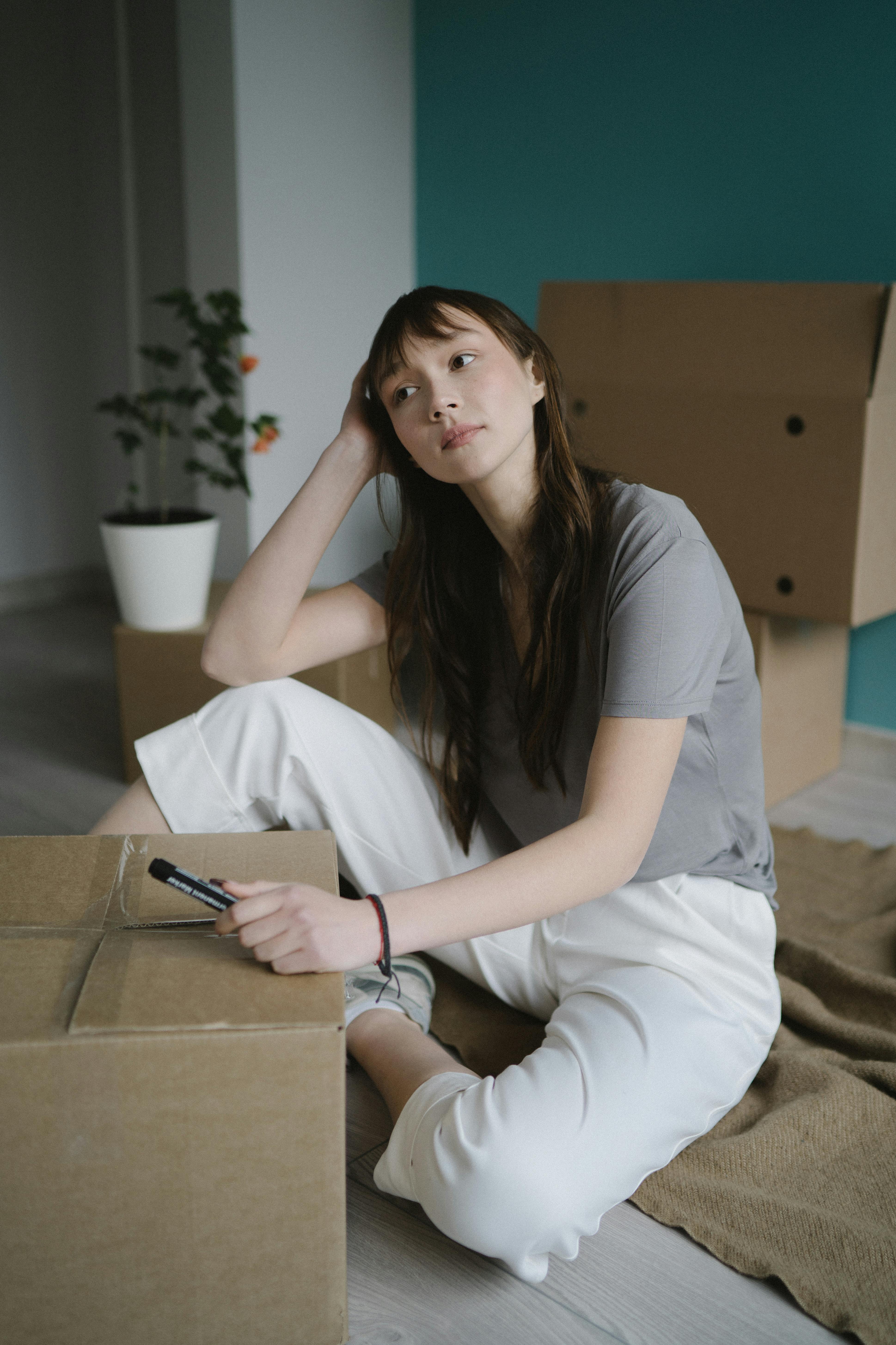 A woman sitting beside a cardboard box | Source: Pexels