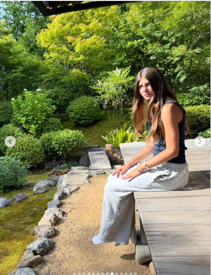 Tom Brady's "forever baby girl," Vivian Brady sits on a wooden platform, as seen from a post dated December 5, 2025. | Source: Instagram/tombrady