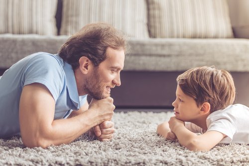Vater und Sohn liegen auf dem Teppich | Quelle: Shutterstock
