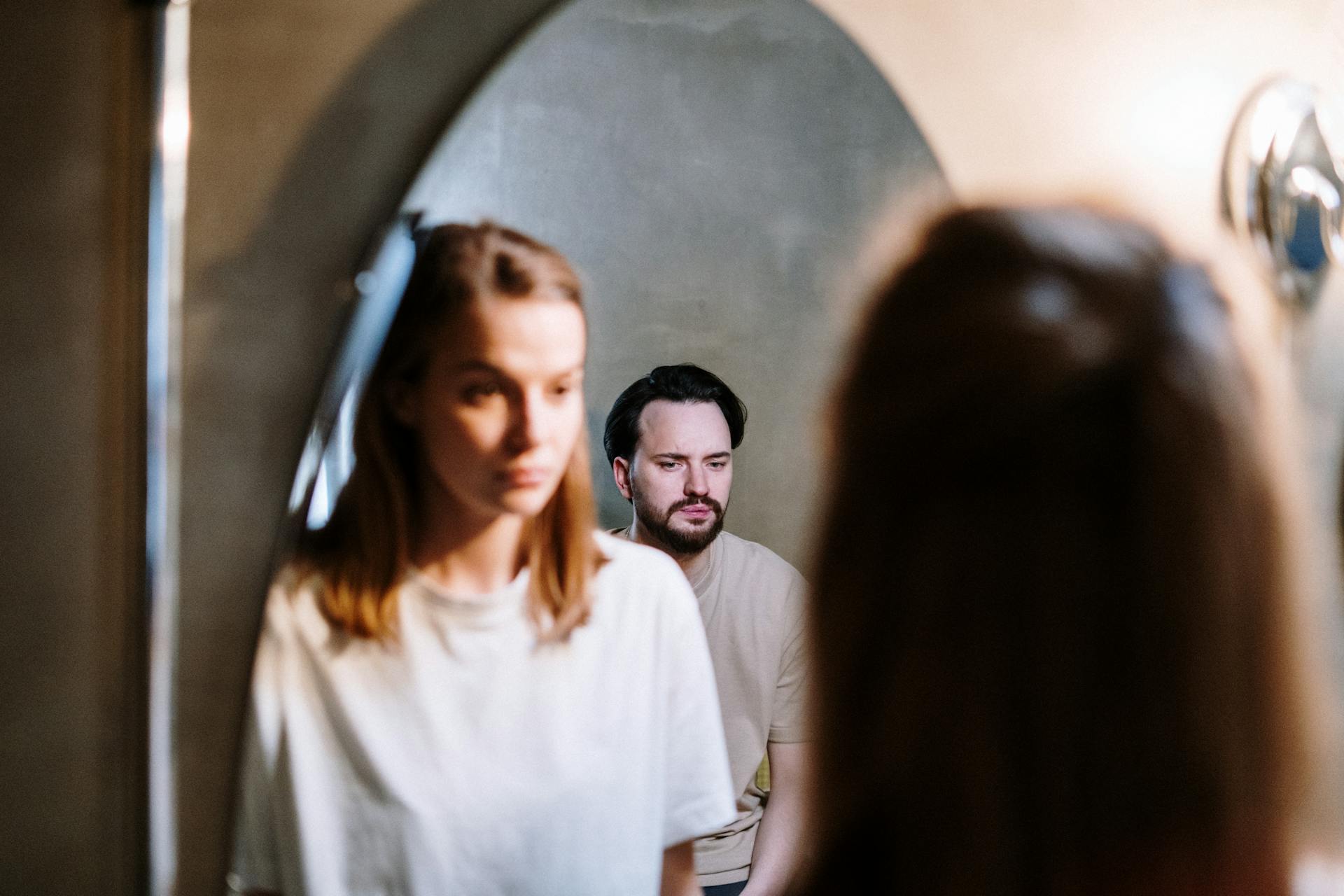 A woman looking at her husbands reflection in the bathroom mirror | Source: Pexels