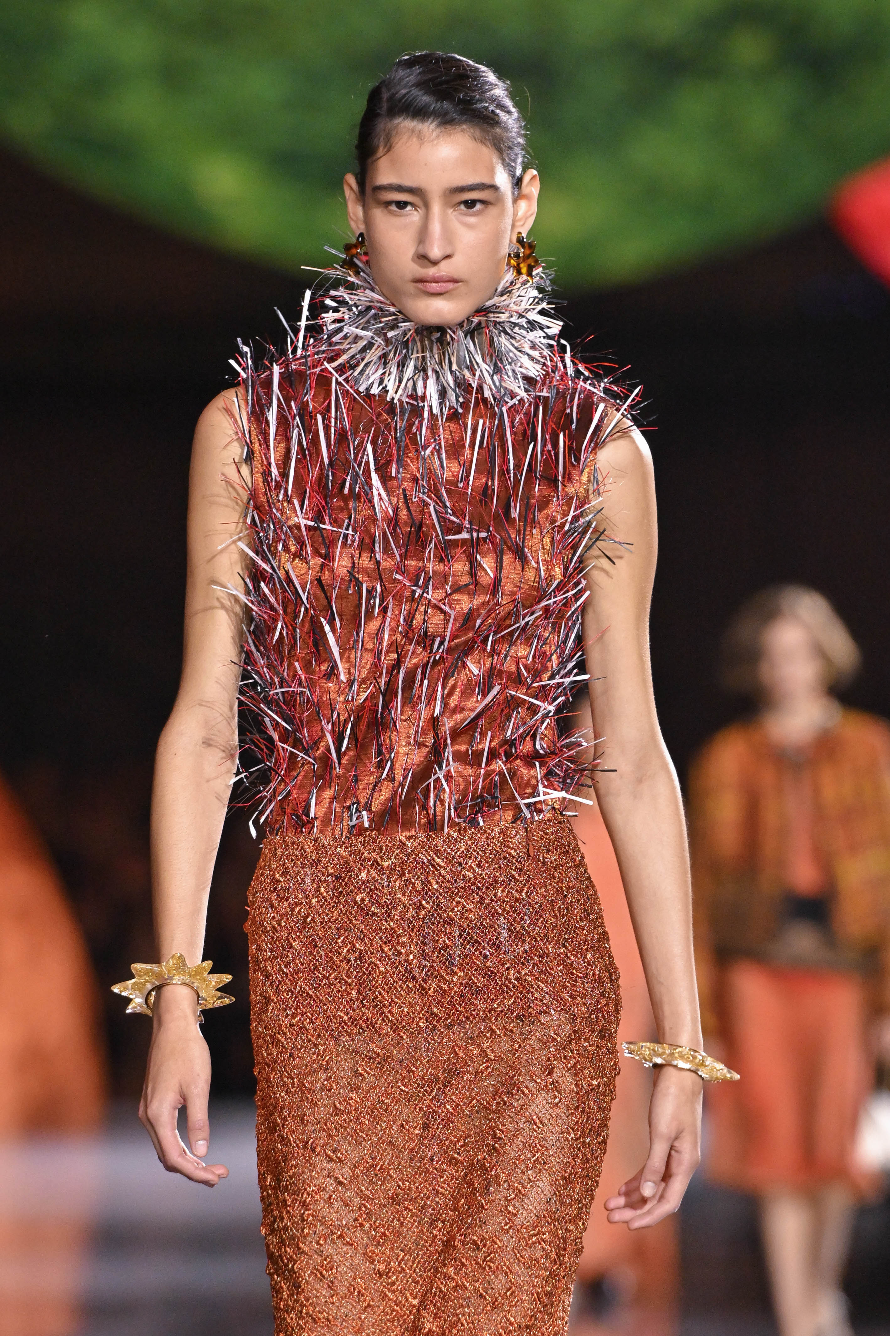 A model walks the runway during the Chanel Ready-to-Wear Spring/Summer 2026 show at Paris Fashion Week in France. She wears a brown dress with a classic skirt, while the upper part is reimagined with striking, spike-like details.