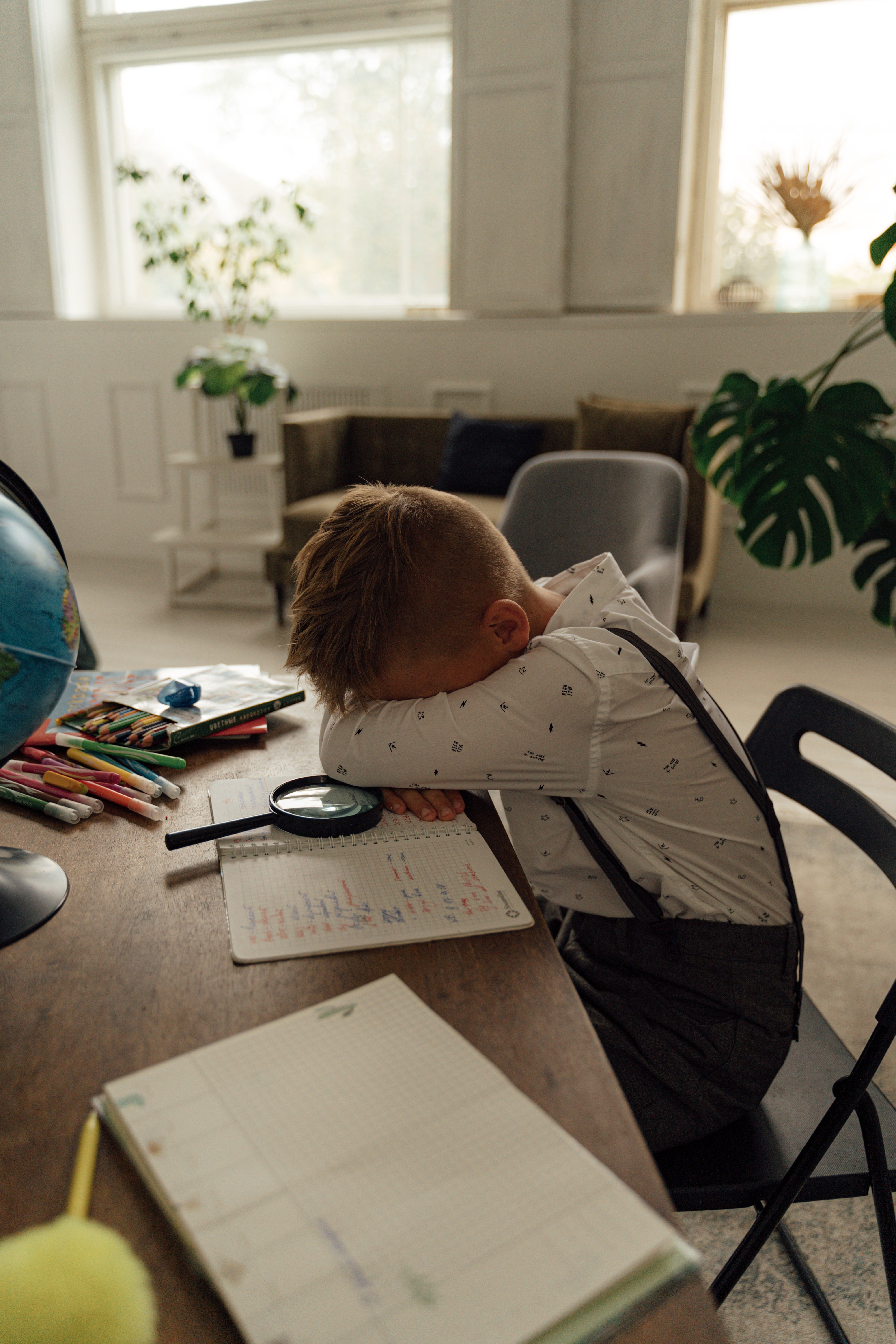Un niño recostado sobre su mesa de trabajo. | Foto: Pexels