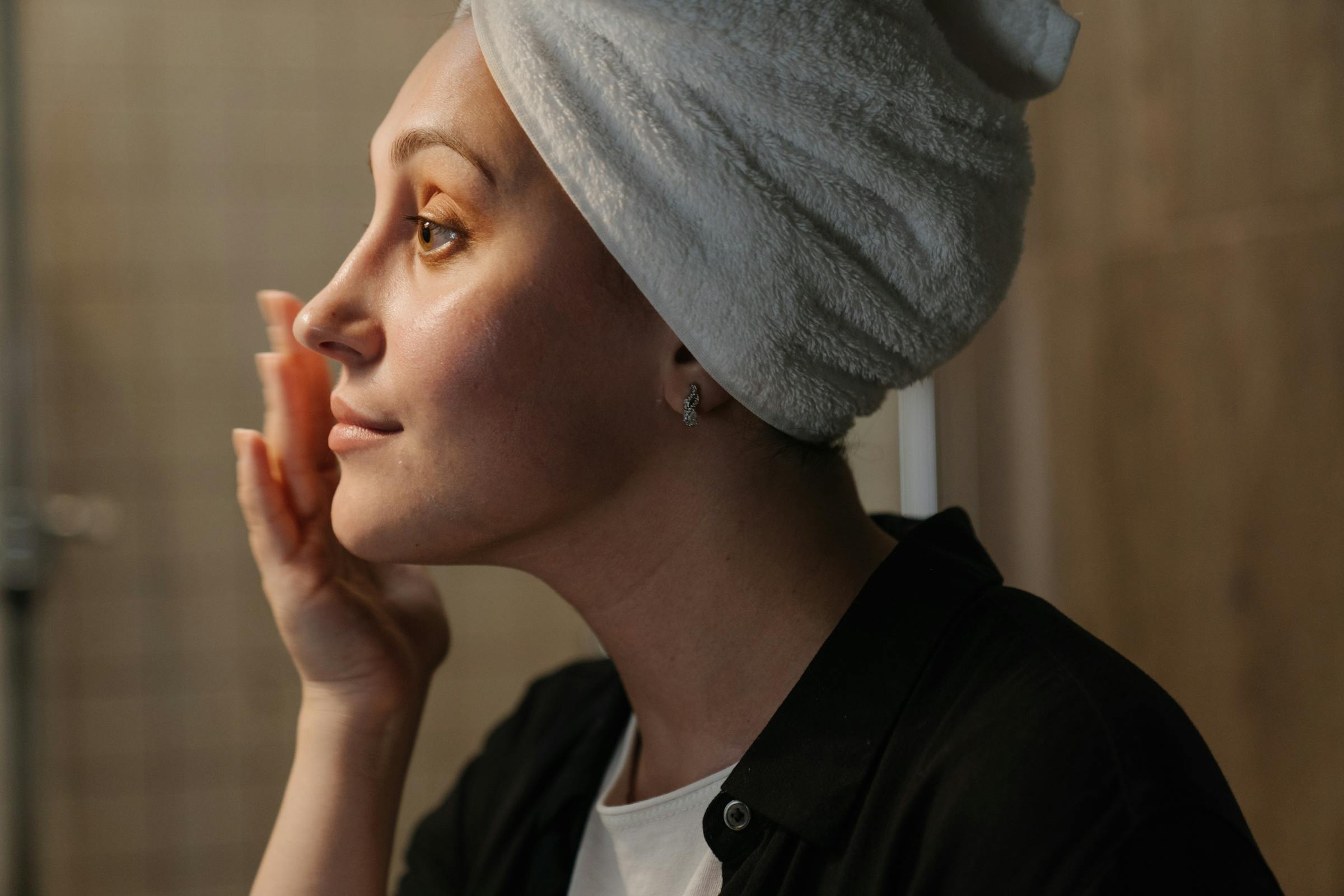 Woman putting face cream on | Source: Pexels