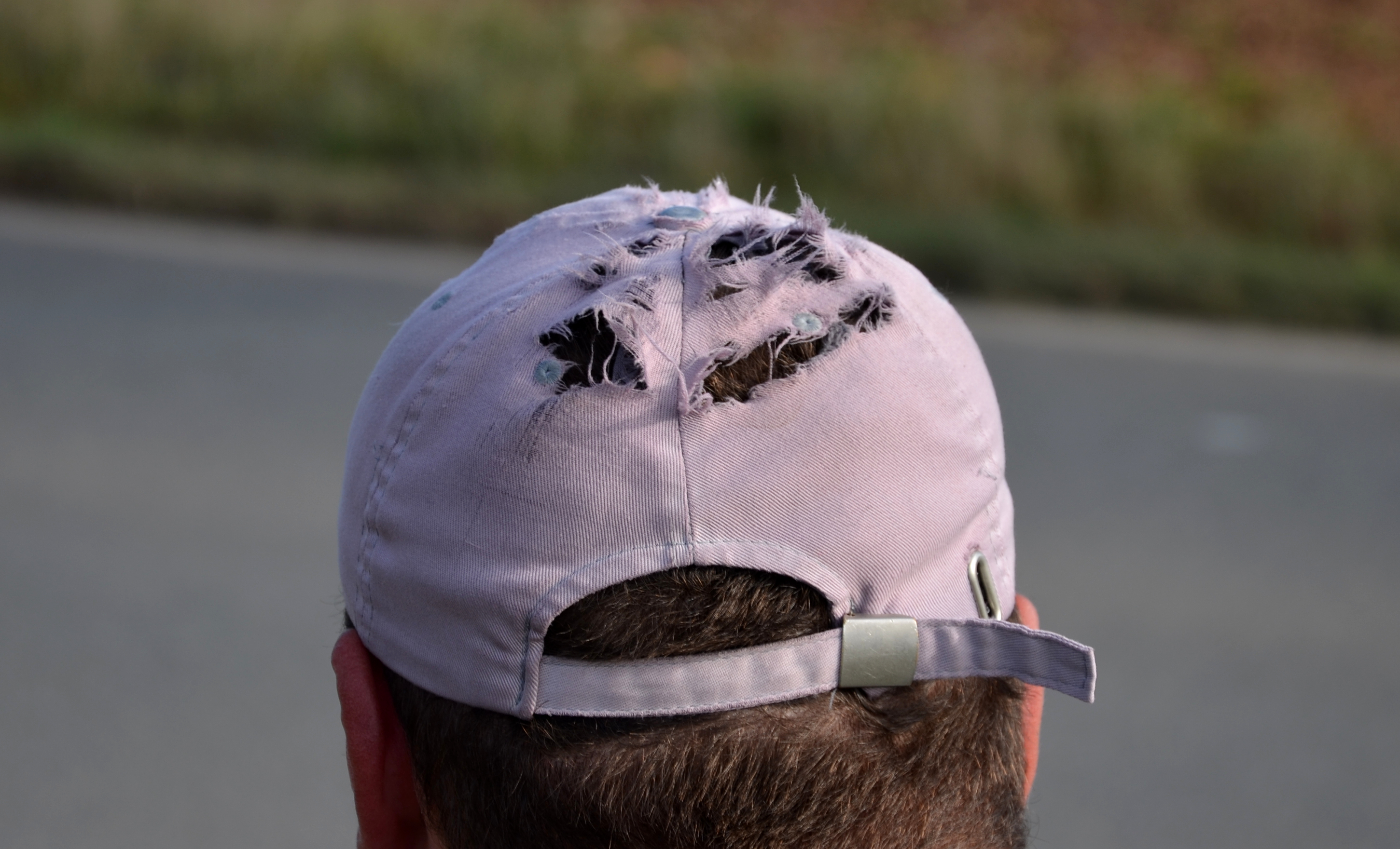Torn baseball cap on man's head | Source: Shutterstock