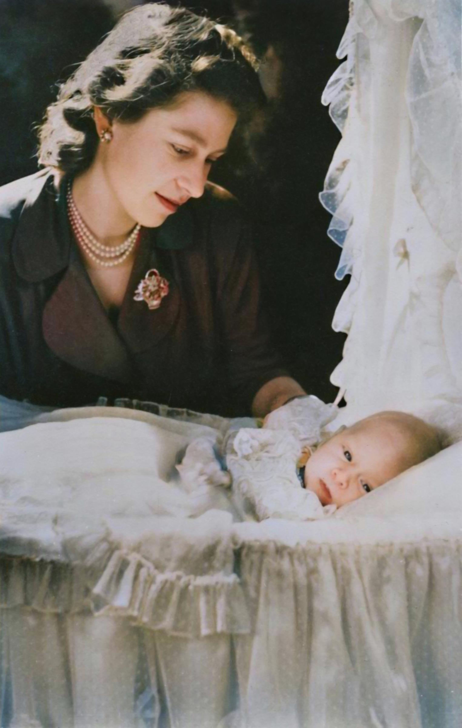 In a tender archival photograph from 1948, Queen Elizabeth II, then still a princess, is captured gazing lovingly at her infant son, then Prince Charles, as he rests in an ornate pram, the intimate moment offering a rare glimpse into the early bond between the future Queen Elizabeth II and her firstborn, long before either would assume their historic roles.