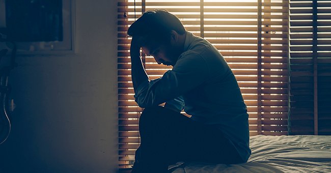 A worried man sitting on his bed | Photo: Shutterstock