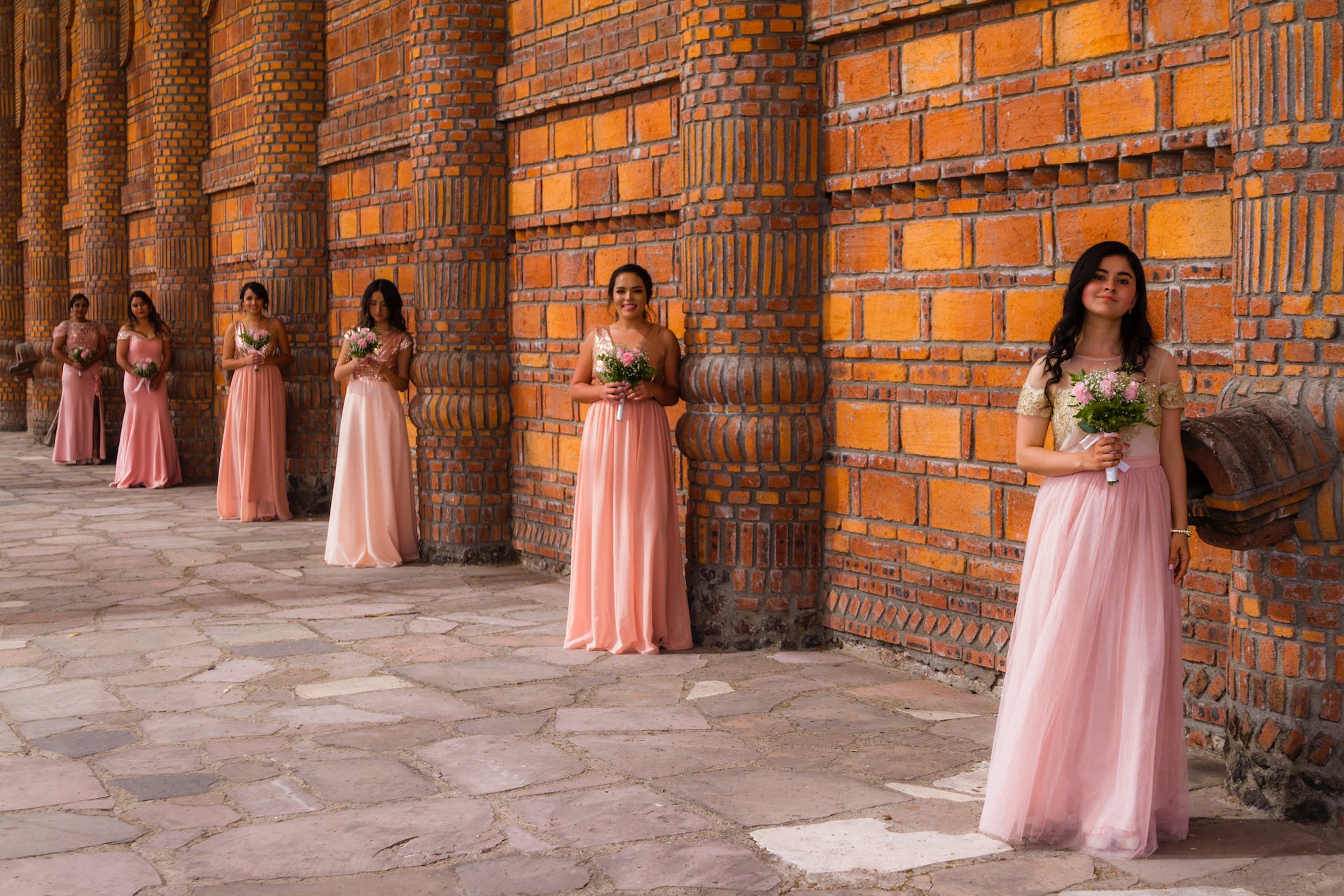 Women in pink dresses holding flowers | Source: Pexels