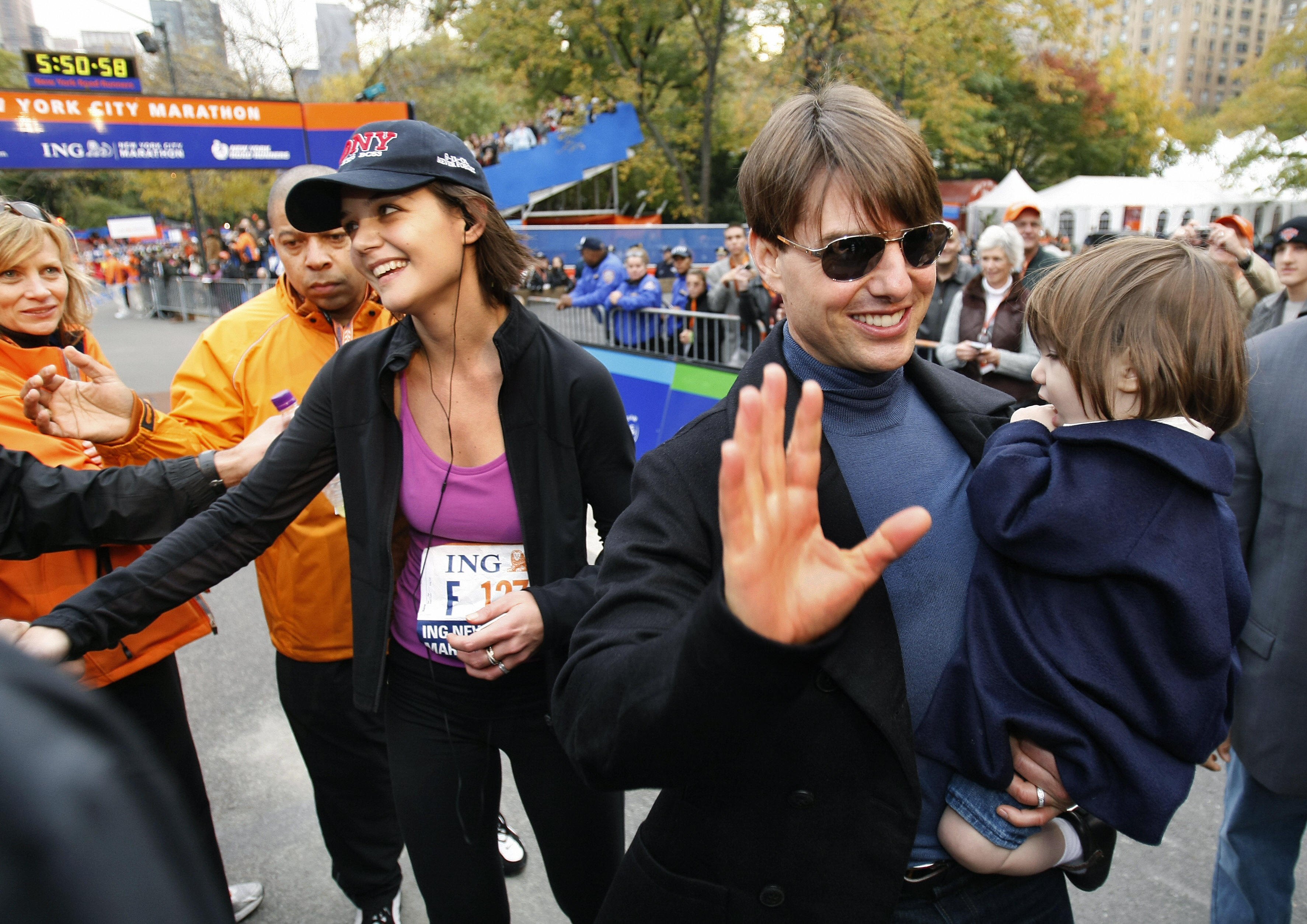 Ο Τομ Κρουζ με την κόρη του Σούρι συναντούν την Κέιτι Χολμς στη γραμμή τερματισμού του Μαραθωνίου της Νέας Υόρκης το 2007. |  Πηγή: Getty Images