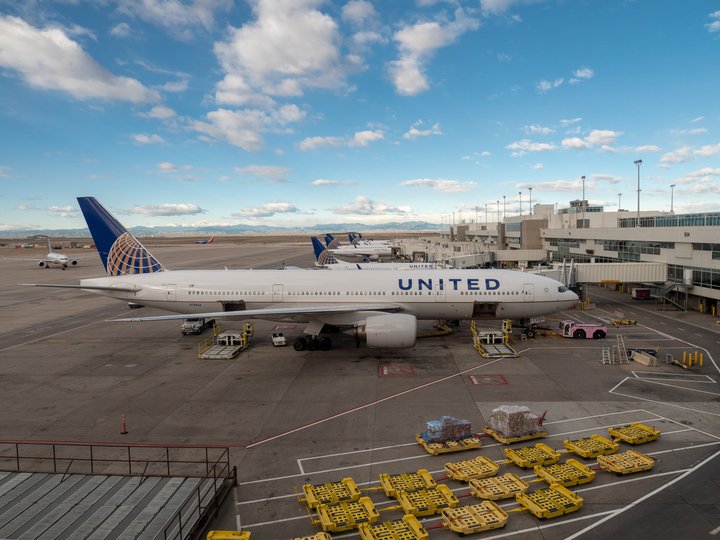 A United Airlines Boeing 777-200 at Denver International Airport with two open cargo holds ready to load nearby in Denver, Colorado | Photo: Myra Thompson via Shutterstock