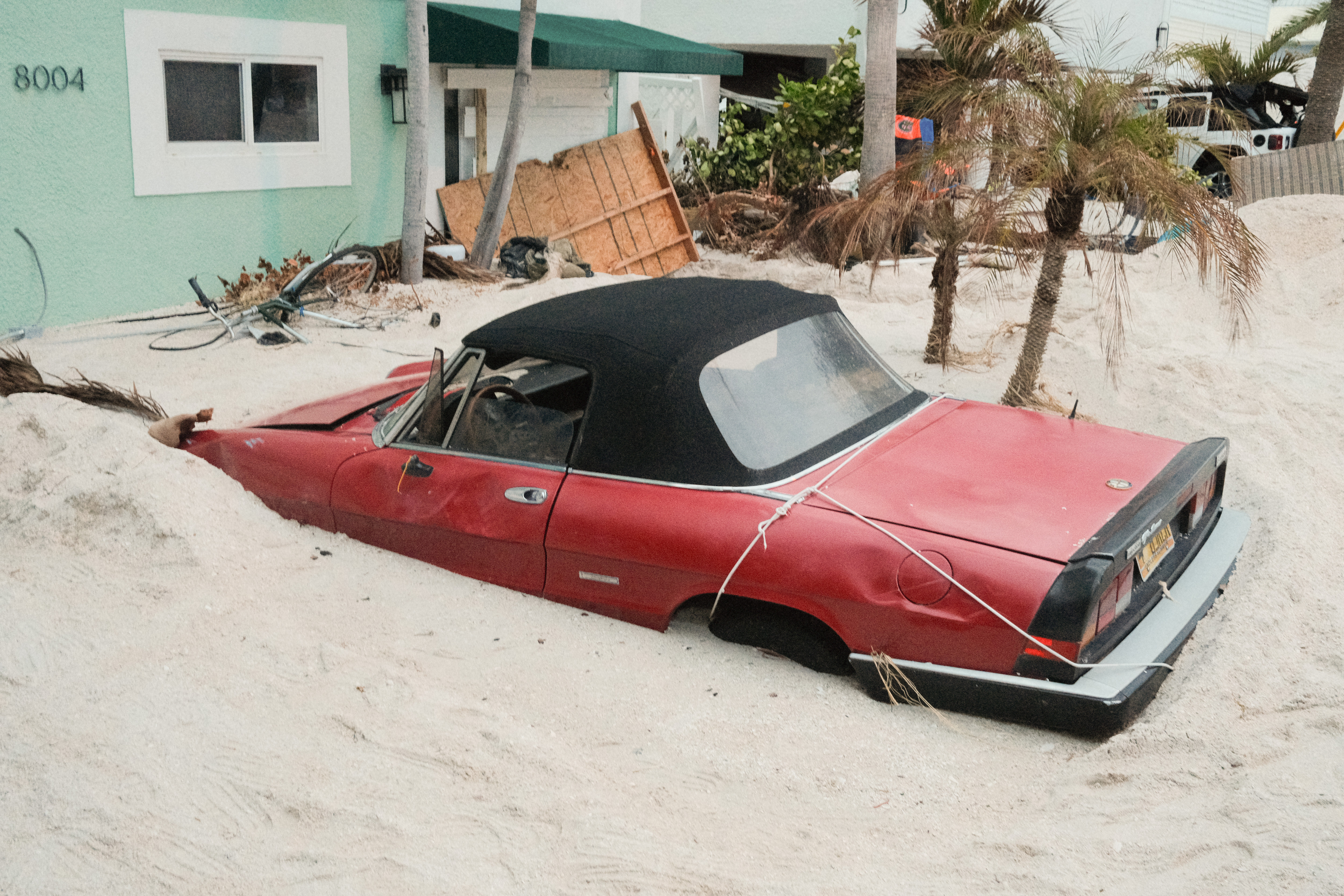 A damaged vehicle stuck in sand swept up by Hurricane Helene ahead of Hurricane Miltons landfall in Treasure Island, Florida, on October 7, 2024 | Source: Getty Images