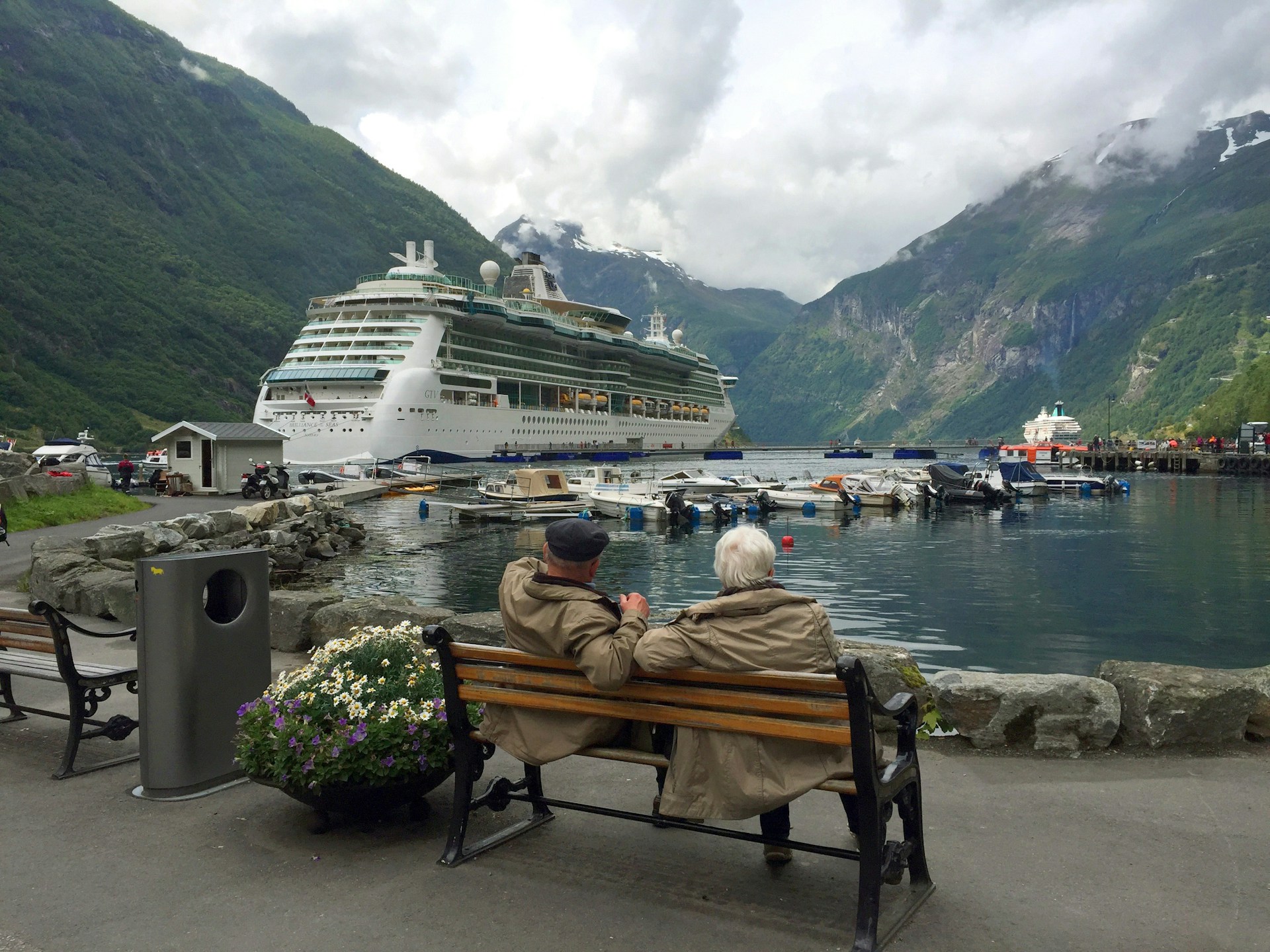 A senior couple sitting on a bench watching a cruise ship | Source: Unsplash