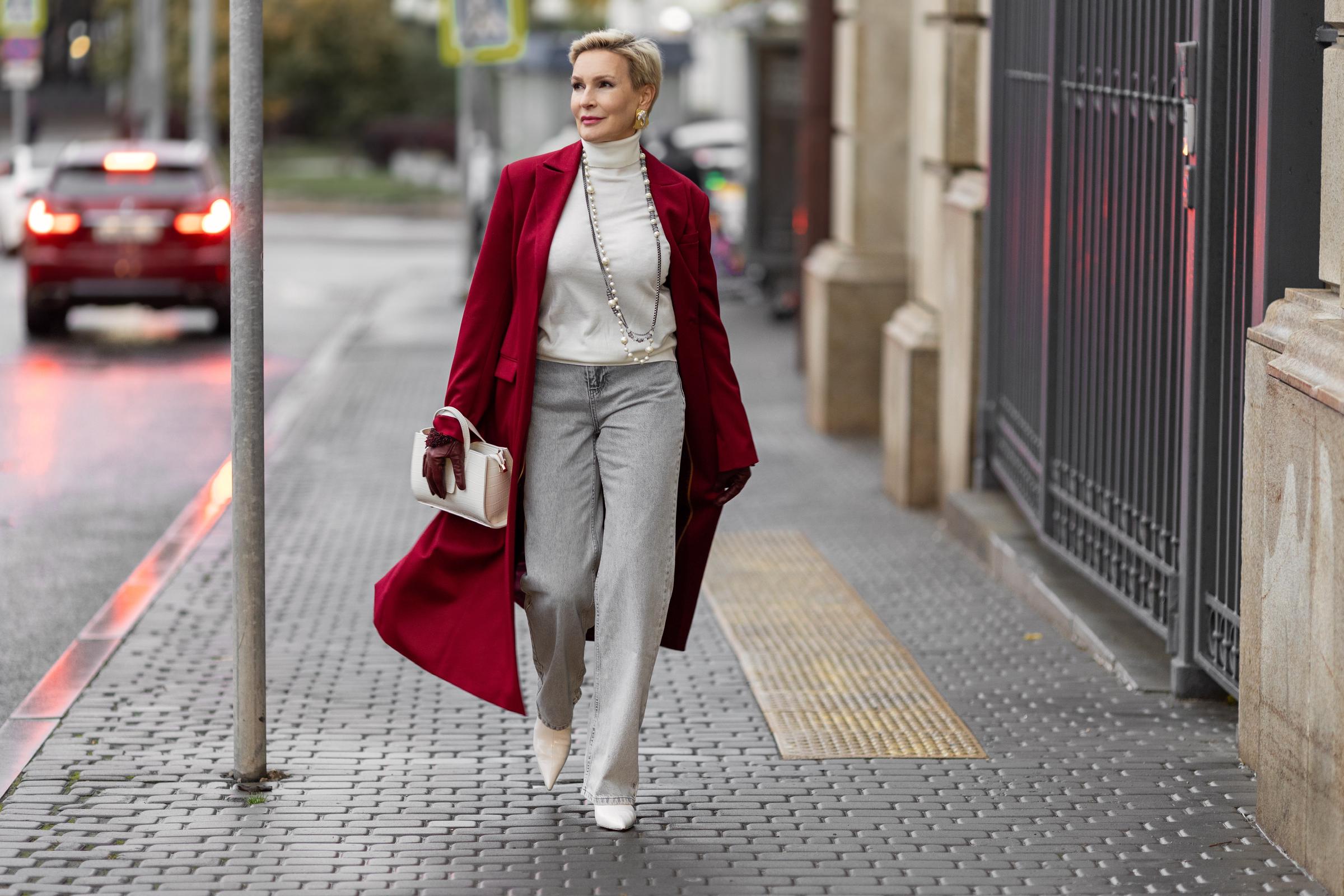 Woman walking in the street in a burgundy coat | Source: Shutterstock