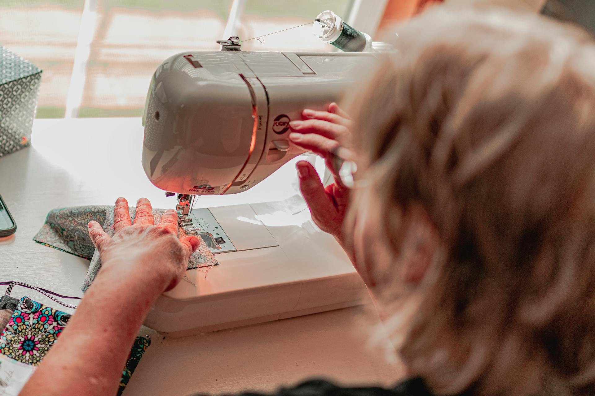 A woman using a sewing machine | Source: Pexels
