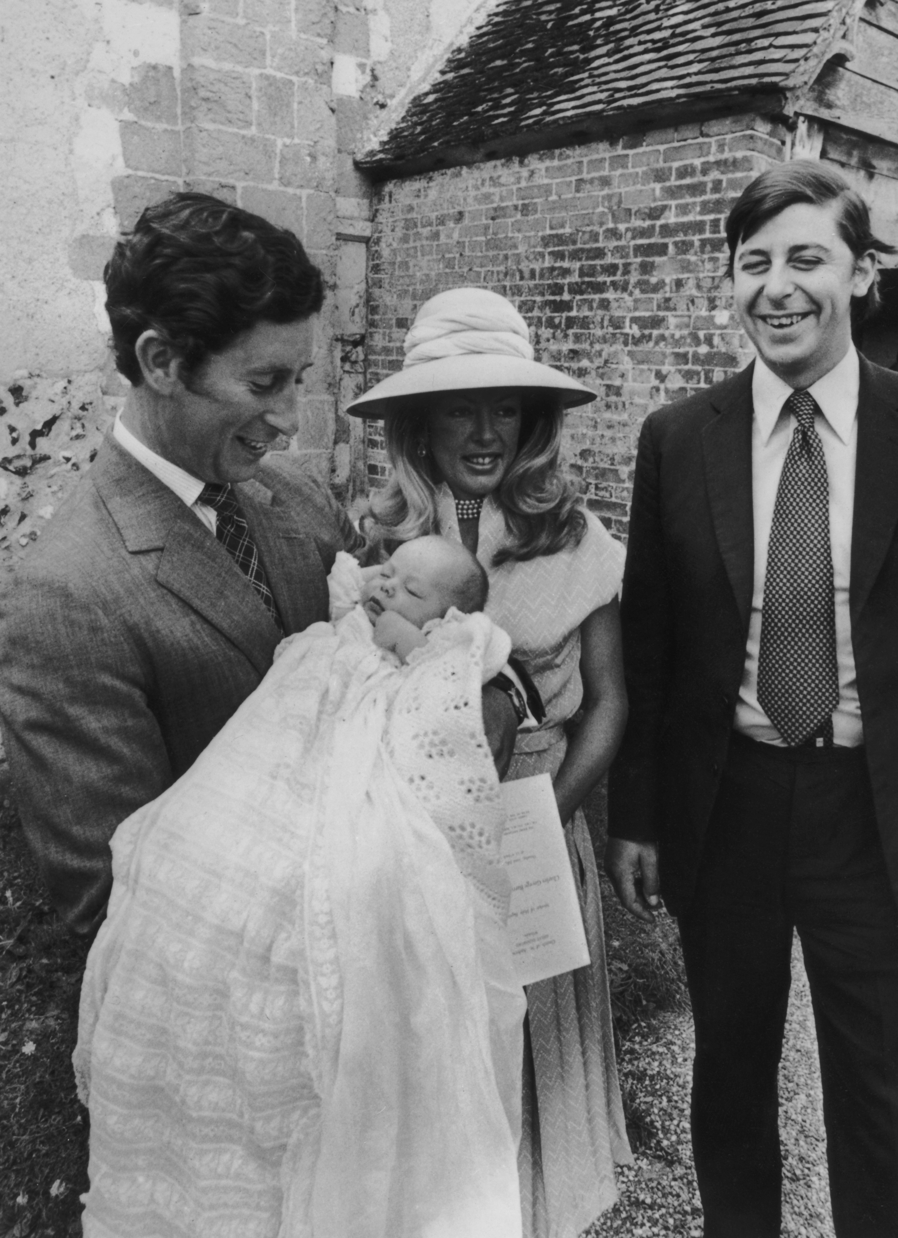 Prince Charles with Lady Dale Tryon, Lord Anthony George Merrick Tryon, and their son, Charles, during his baptism on July 23, 1976 at the Church of St Andrews, Durnford, Wiltshire | Source: Getty Images