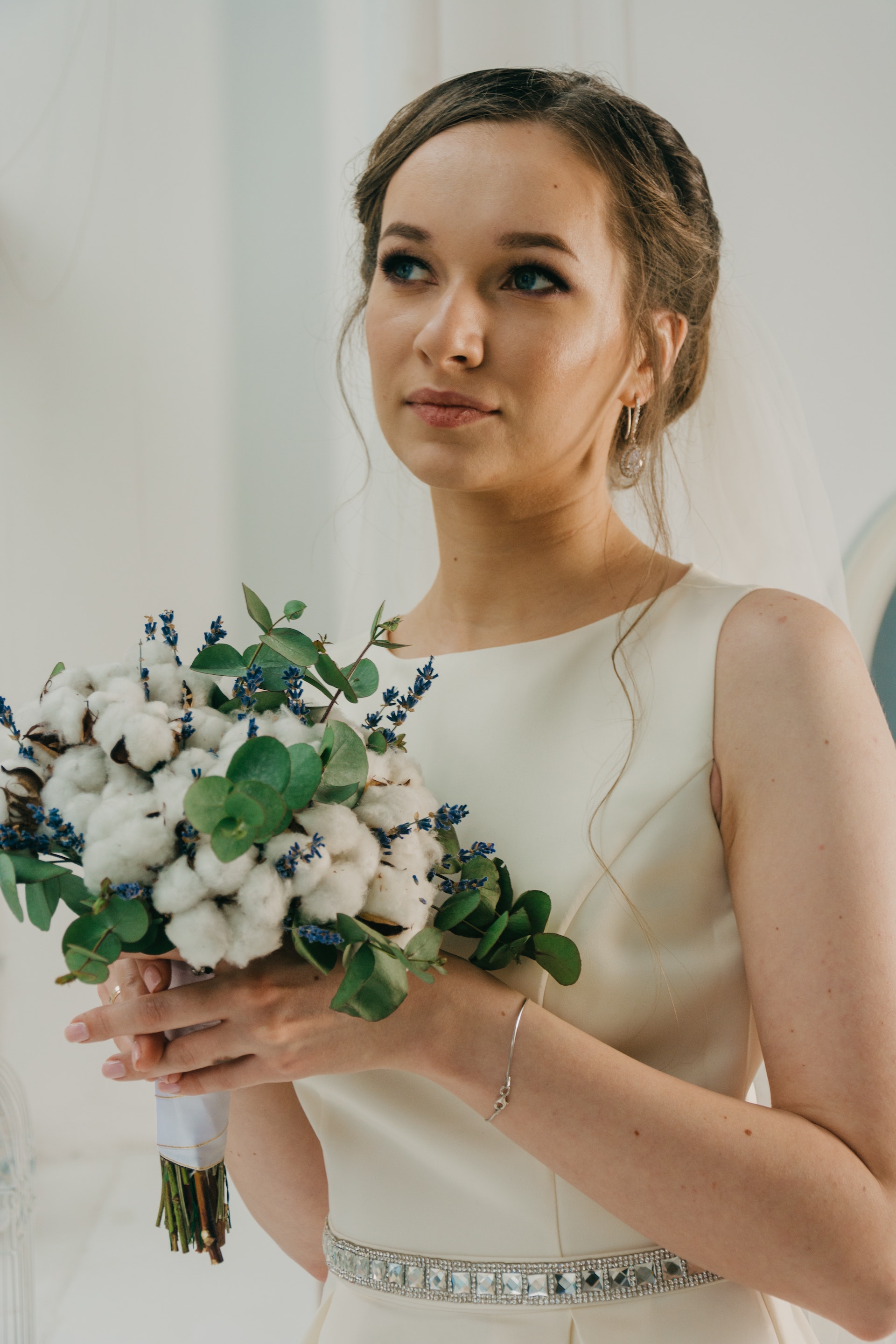 A woman in a white gown holding a bouquet of flowers | Source: Pexels