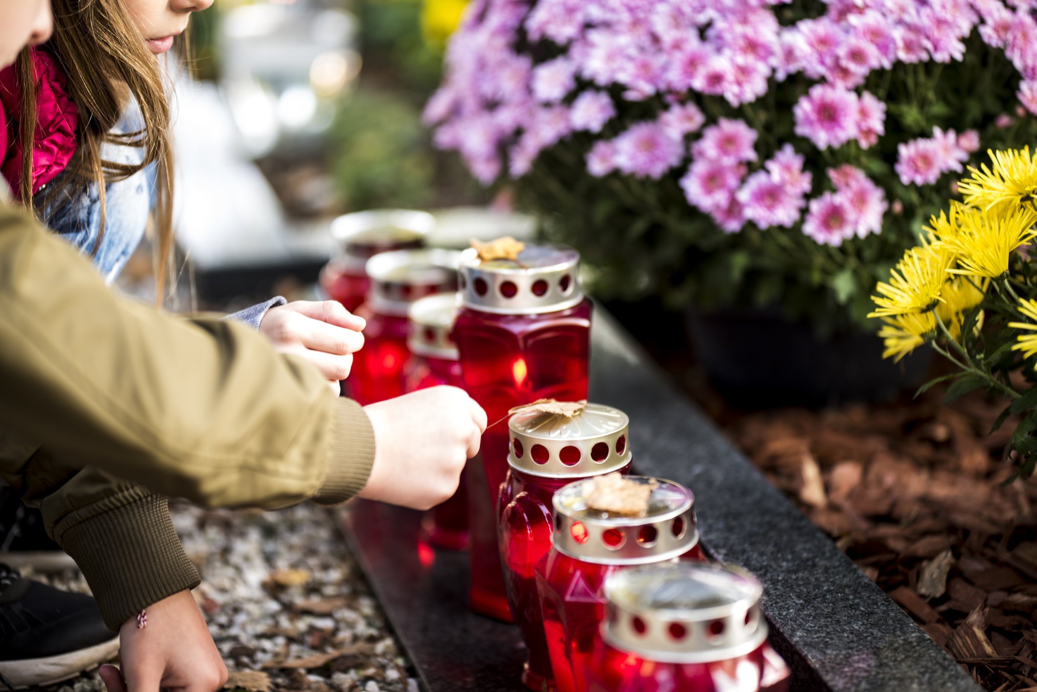 Kinder mit Kerzen am Grab | Quelle: Getty Images