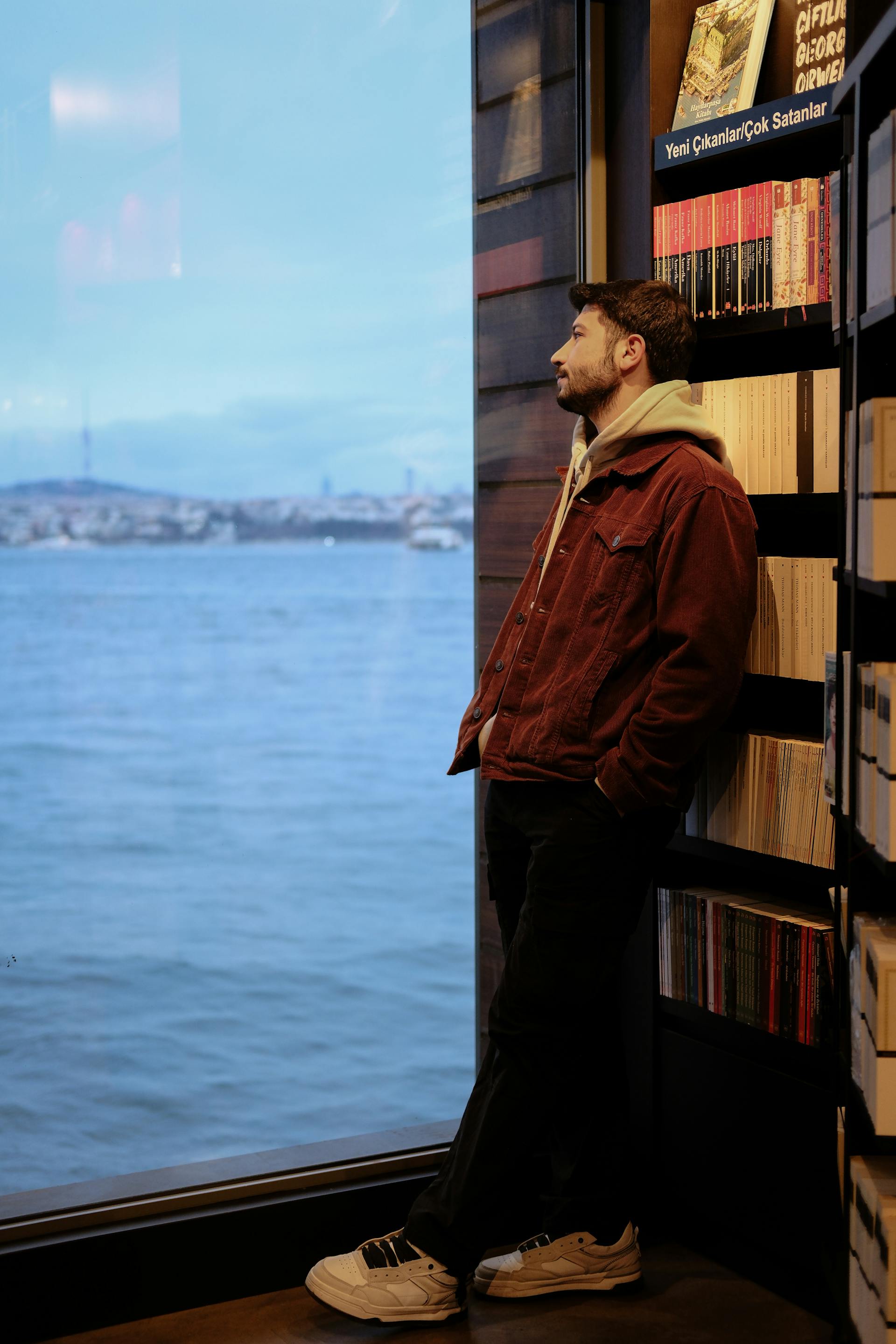 A man standing by a window looking outside | Source: Pexels