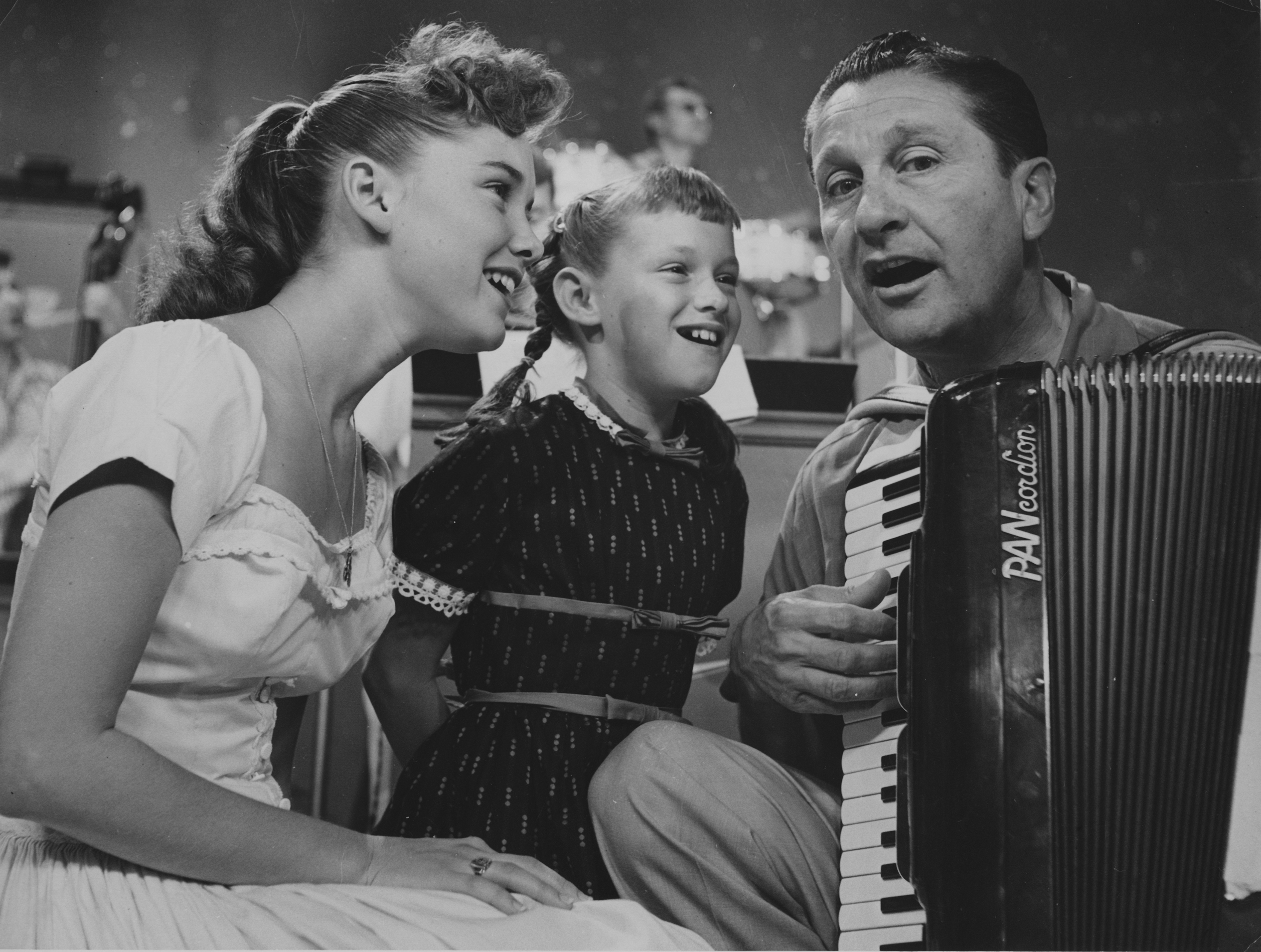 Dianne and Janet Lennon with Lawrence Welk singing together on "The Lawrence Welk Show" in 1955 | Source: Getty Images
