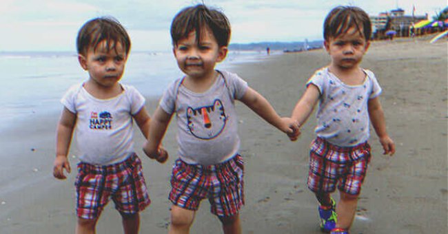 Little triplets walking on the beach | Source: Shutterstock