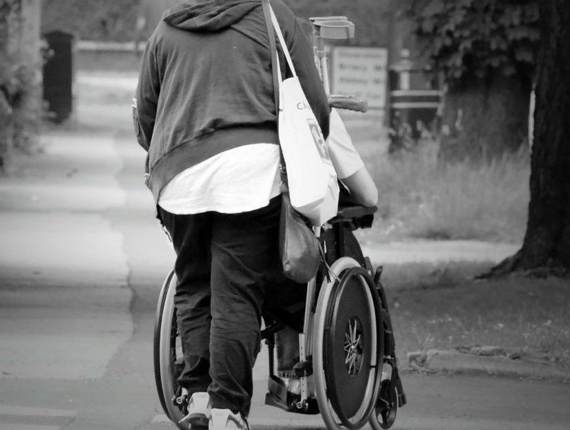 Una mujer empuja una silla de ruedas. | Foto: Pixabay