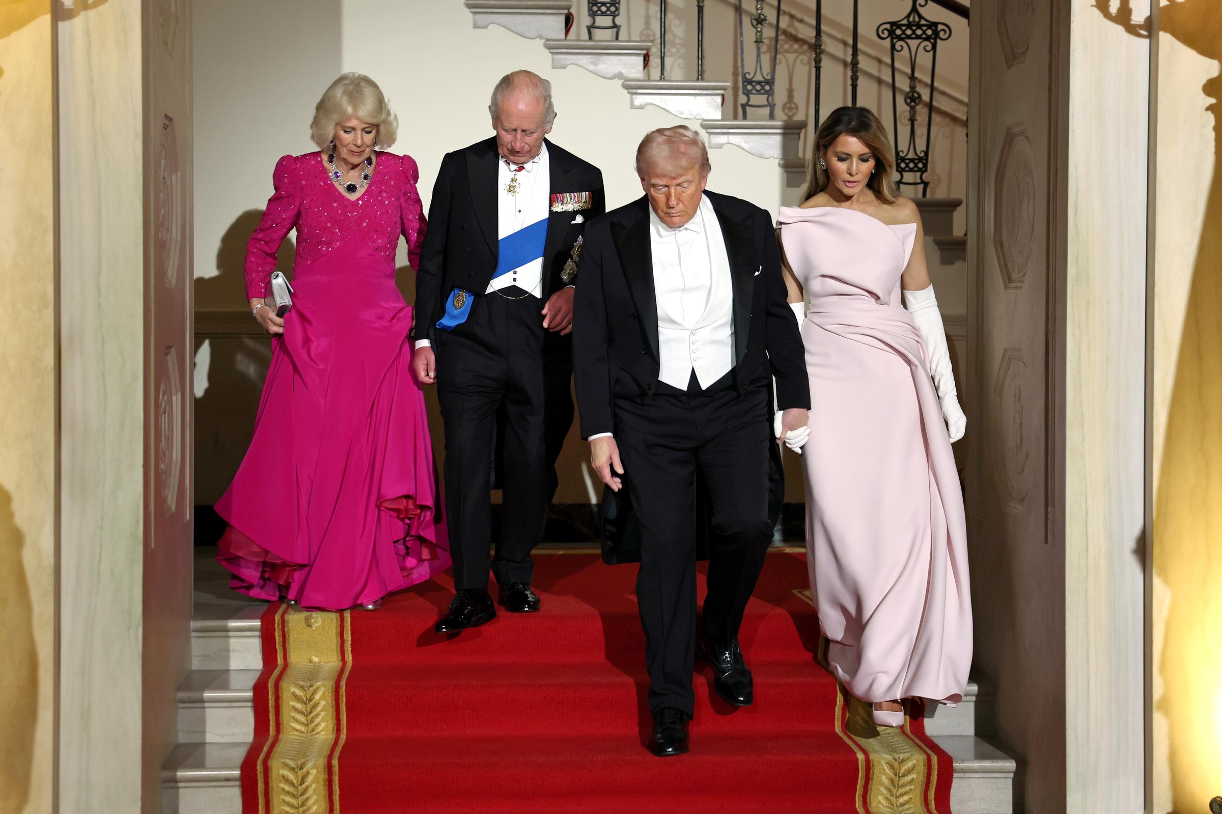 Queen Camilla, King Charles III, U.S. President Donald Trump, and First Lady Melania Trump descend the Grand Staircase during an official state dinner hosted by the President and First Lady at The White House on day two of the State Visit of King Charles III and Queen Camilla to the United States of America, on 28 April 2026 in Washington, DC. | Source: Getty Images