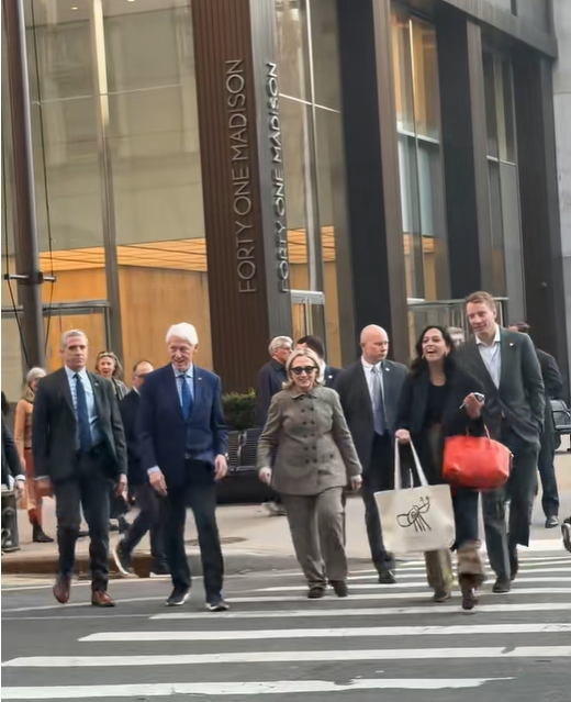 Hillary Clinton walks across a zebra-striped crosswalk outside the building in New York City, accompanied by Bill Clinton and several aides. | Source: TikTok/elderordonez