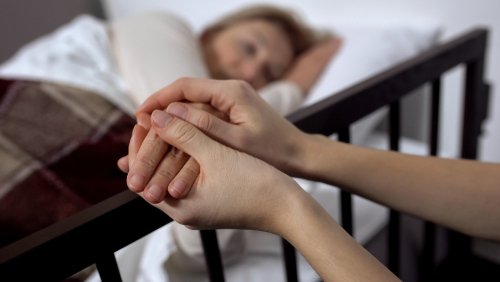 Mujer toma la mano de una paciente en el hospital. | Foto: Shutterstock