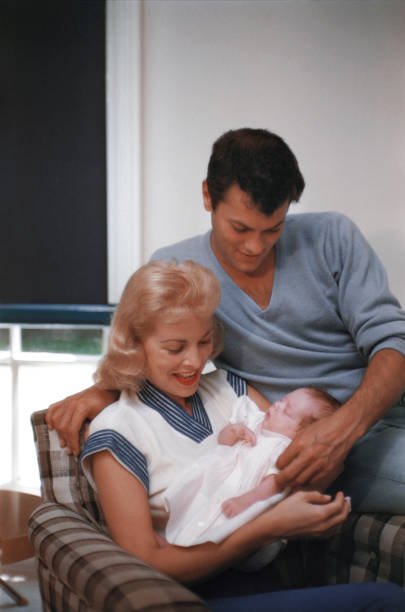 Actors Janet Leigh and Tony Curtis pose for a portrait with their baby daughter Kelly Curtis at home on August 4, 1956 in Los Angeles, California | Source: Getty Images