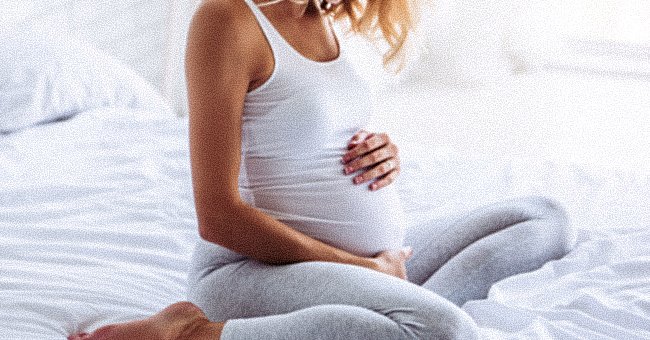 Une femme regarde son ventre | Photo : Shutterstock