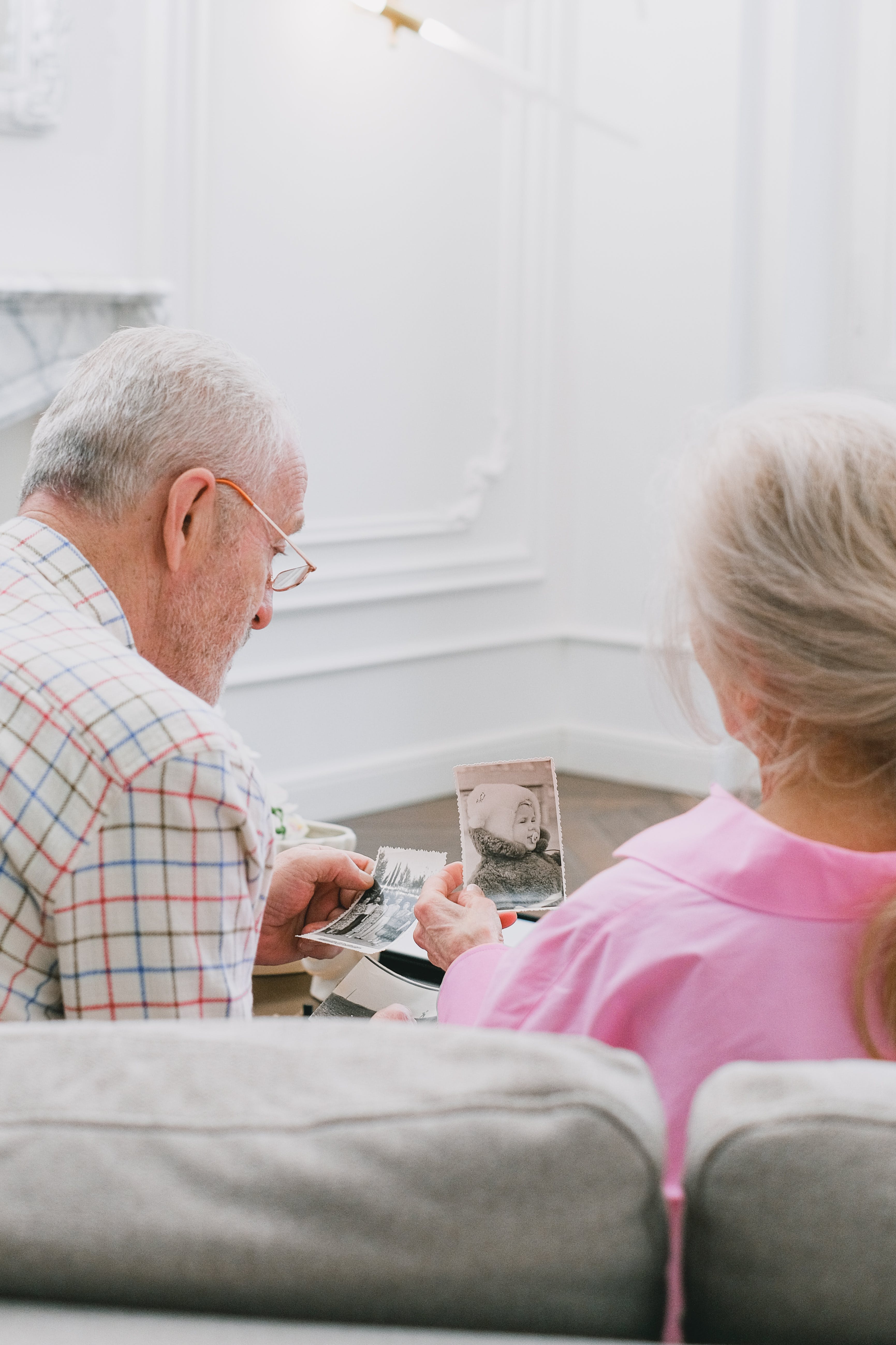 An elderly couple looking at photographs together | Source: Pexels