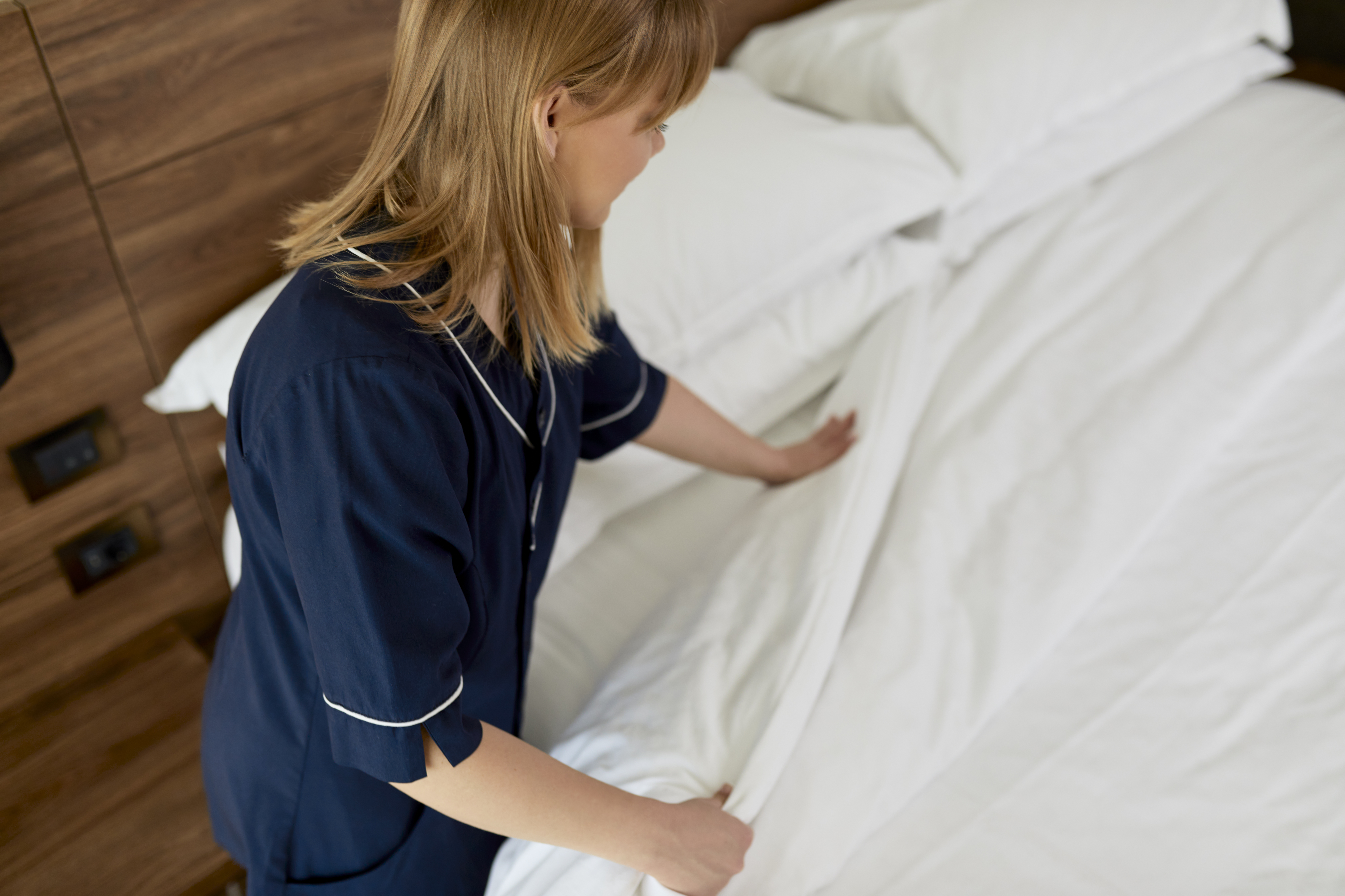 Hotel maid makes the bed | Source: Getty Images