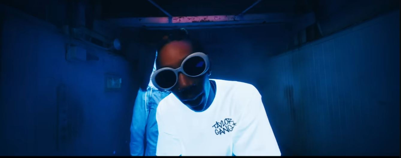 Wiz Khalifa pairs oversized white retro bug-eye frames with a minimalist look in a scene from the "Bake Sale" music video. | Source: YouTube/Wiz Khalifa