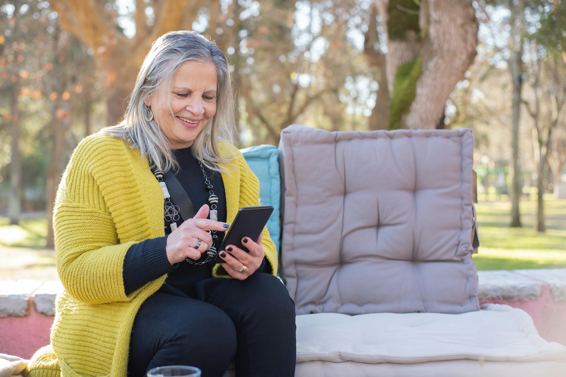 A happy woman using her smartphone | Source: Pexels